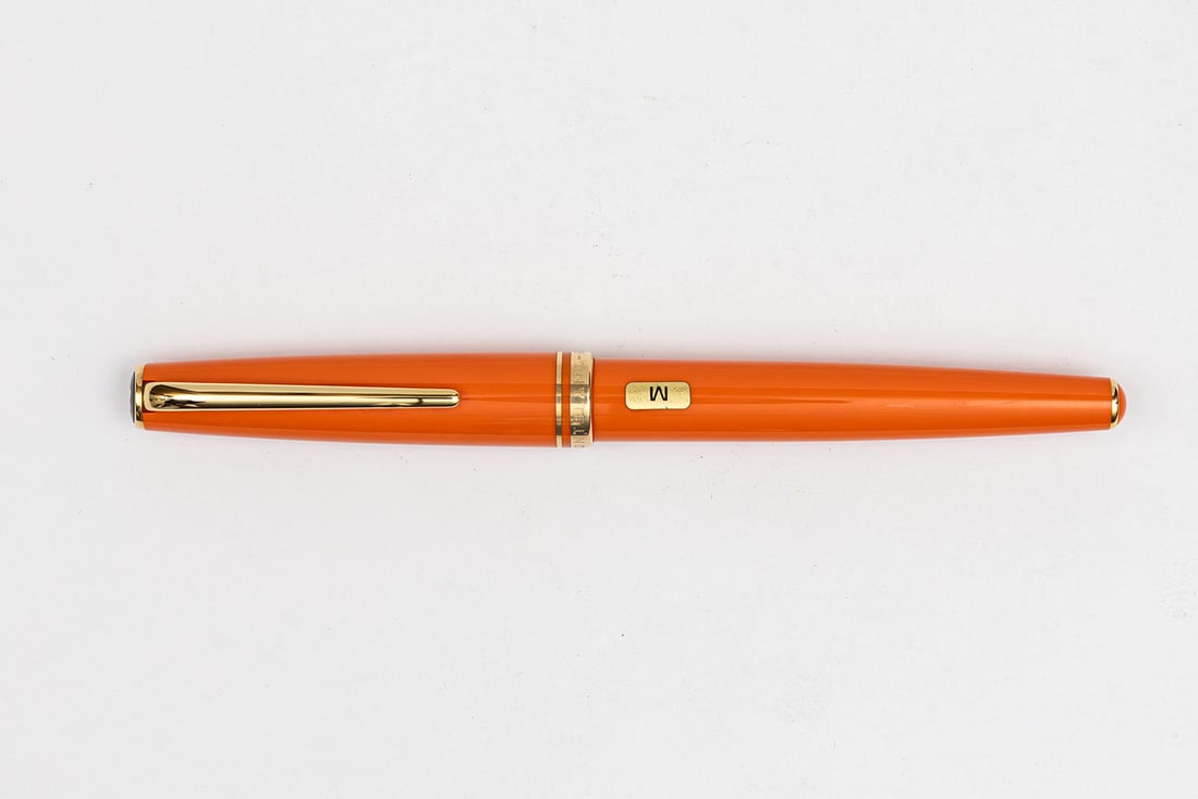 Montblanc Generation Orange Fountain Pen, Boxed: Montblanc Generation orange fountain pen, boxed, circa 1990’s. Bright orange example with 14K medium nib. Length 5 3/8” and 5 3/4” posted, filling mechanism cartridge/converter fill (con