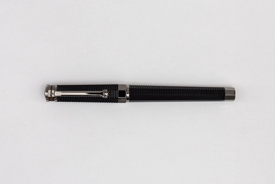 Montegrappa Neruno Linea Fountain Pen, 18K Nib: Montegrappa Nero Linea fountain pen with box, outer box and papers. Multisided ribbed flat black pen with silver coloured trim and roller clip, 18K medium nib. Length 5 5/8” and 6 1/2” pos