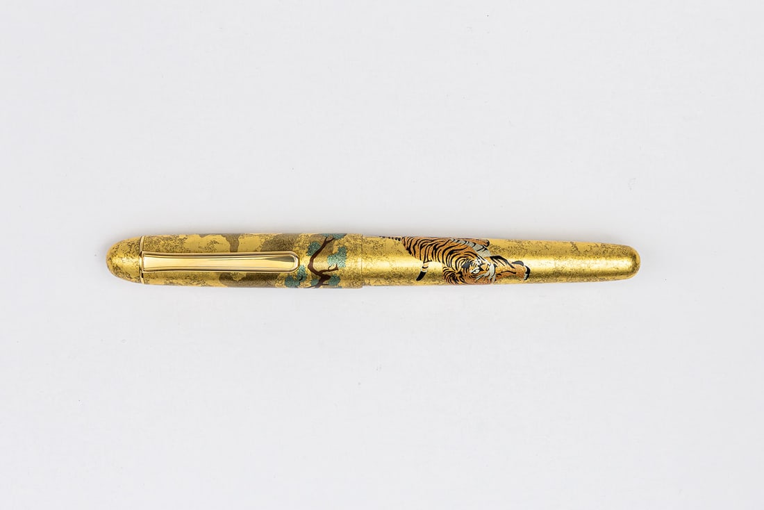 Platinum 3776 Kanazawa-Haku Matsu-Tora Pine Tree & Tiger Fountain Pen: Platinum 3776 Century Kanazawa-Haku Matsu-Tora Pine Tree & Tiger fountain pen. Platinum Century fountain pen with pine tree on cap and tiger on barrel with Platinum fine 14K nib. Length 5 1/2” a