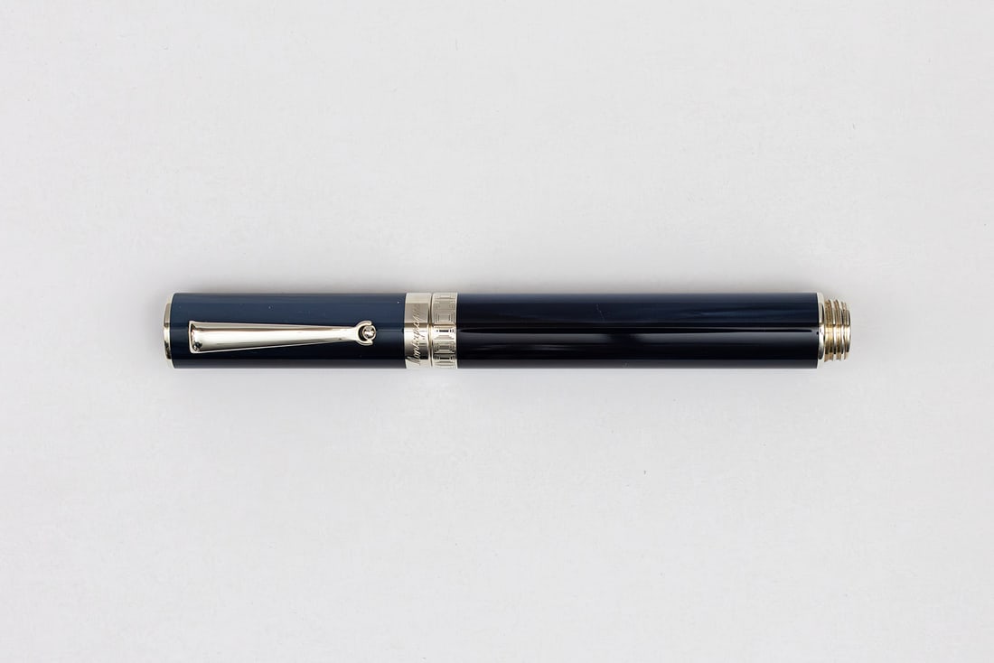 Montegrappa Espressione Blue Fountain Pen, 18K Nib: Montegrappa Espressione Blue fountain pen. Montegrappa Expressione in mixed blue pearl marble with sterling silver trim and rhodium plate 18K gold fine nib. Length 5 1/4” and 6 3/4” posted