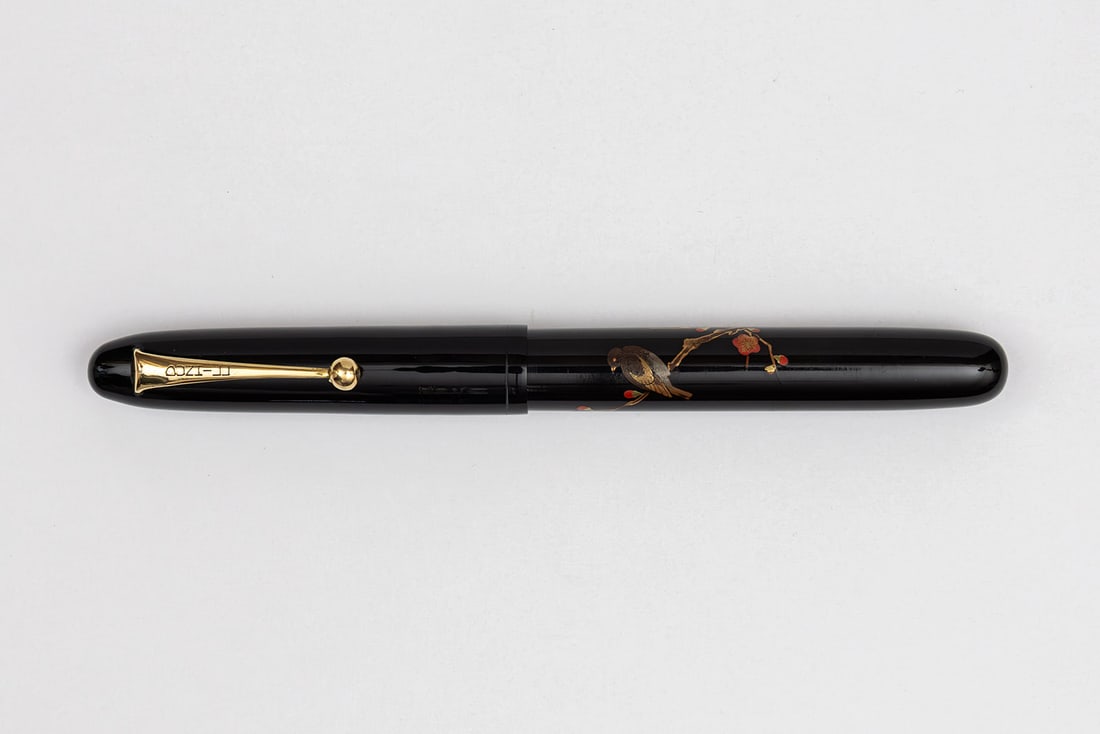 Dunhill Namiki Pilot Bird & Ume Tree Maki-e Lacquer Fountain Pen: Dunhill Namiki balanced form bird on Ume (plum tree) branch togidashi maki-e fountain pen, circa 1930’s. Marked Dunhill on clip and Dunhill Namiki 18K 3 on fine tipped nib, decorative bird sitting o