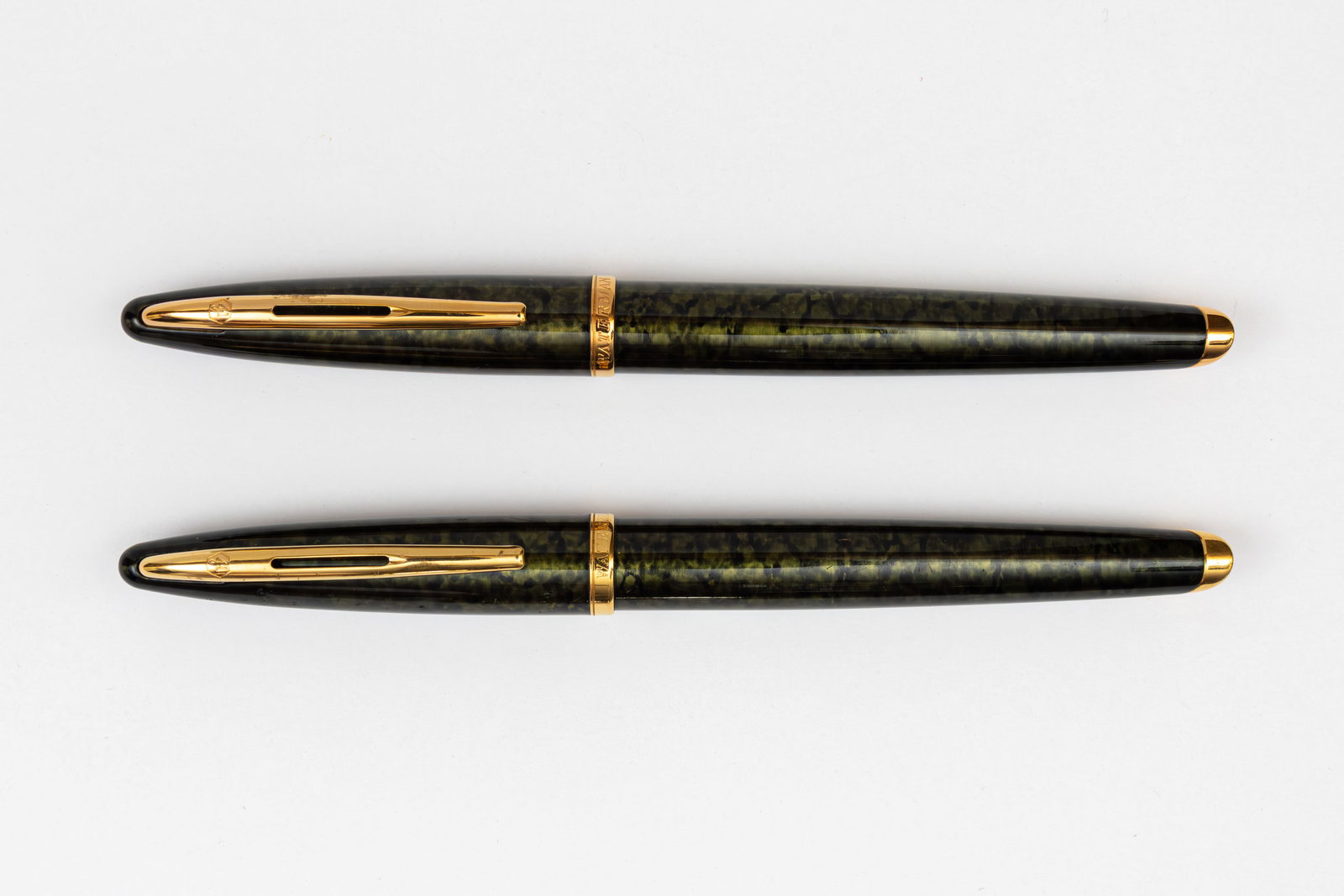 Waterman Carene Green Shimmer Fountain Pen & Rollerball Set: Waterman Carene Green Shimmer fountain pen and rollerball set with box, papers and outer sleeve, circa 1998. Green Shimmer finish with gold trim and 18K fine nib. Length 5 5/8” and 5 3/4”