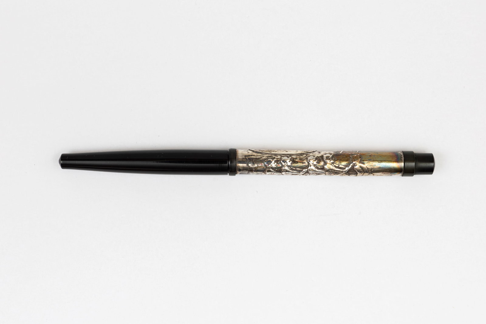 Metal Overlay Taper Cap Silver Fountain Pen, Coxed Four High Relief: Taper cap silver overlay fountain pen with high relief design, circa 1910’s. Black hard rubber taper cap with silver barrel overlay, likely silver plate as metal content is unmarked with high relief