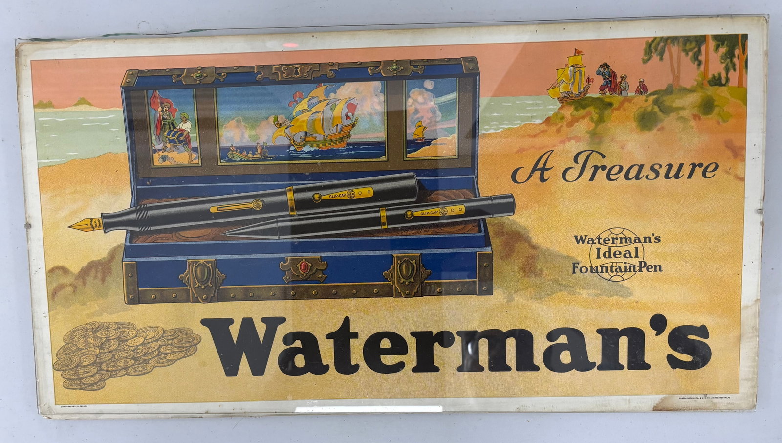 Waterman Ideal Treasure Chest Display Fountain Pen Sign: Waterman Ideal fountain pen display sign. Likely a subway or bus advertising sign in cardboard mounted with glass top measuring 21 inches x 11 inches. Overall fair condition, some staining to edges,