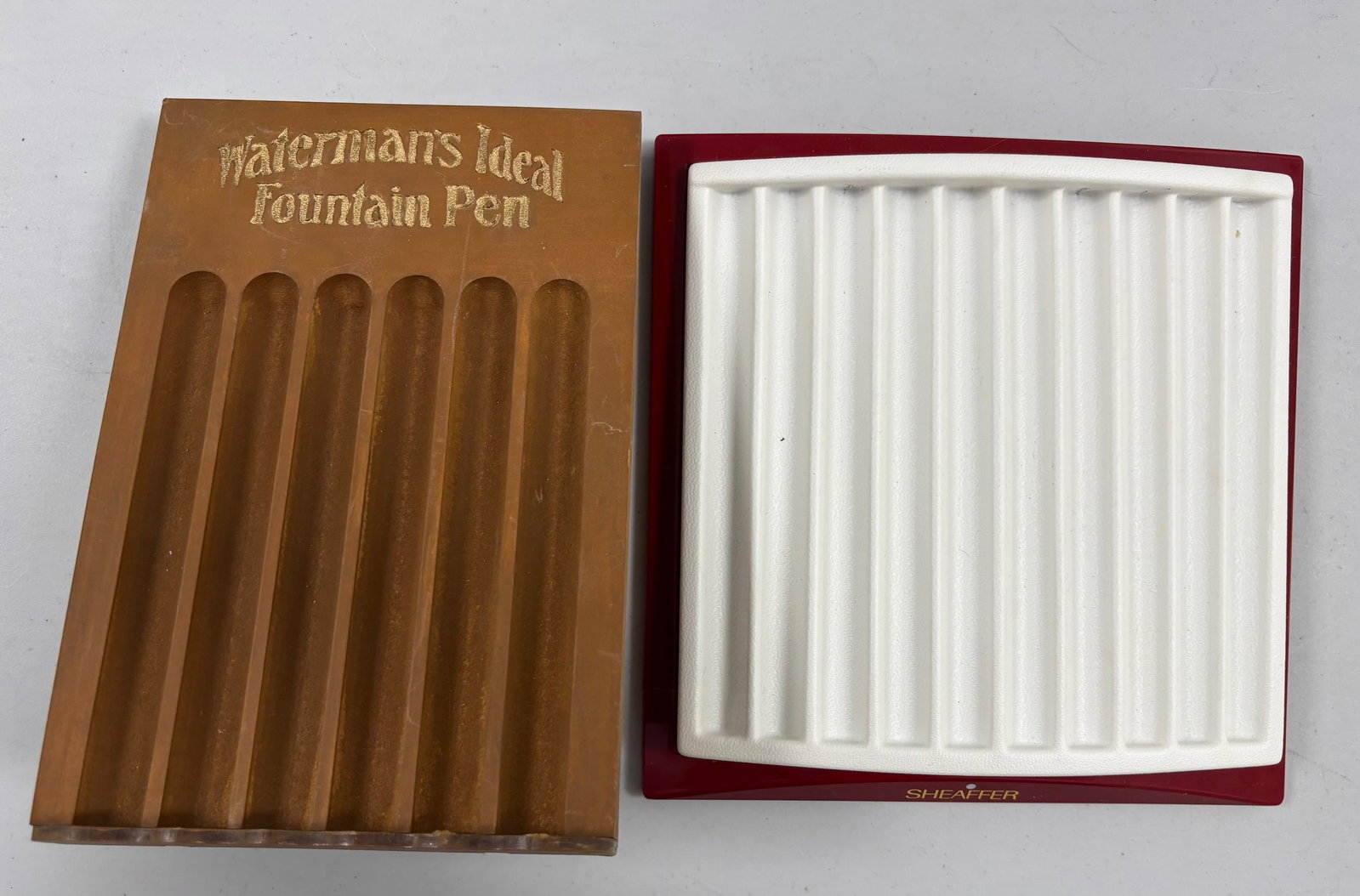 Assorted Fountain Pen Trays and Displays (4): Assorted fountain pen trays and displays (4). Parker and Sheaffer pen trays (1 each), wood Waterman tray made to look vintage and wood display case measuring 17x11 inches in size. Overall good
