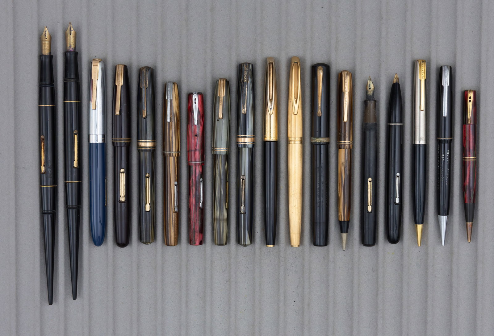 Waterman Fountain Pens and Pencils (18): Waterman fountain pens and pencils (18). 14 fountain pens, 13 pens with 14K solid gold nibs, one 18K along with 4 pencils. Overall mixed as is condition, nibs with good tipping. One pen visibly broken