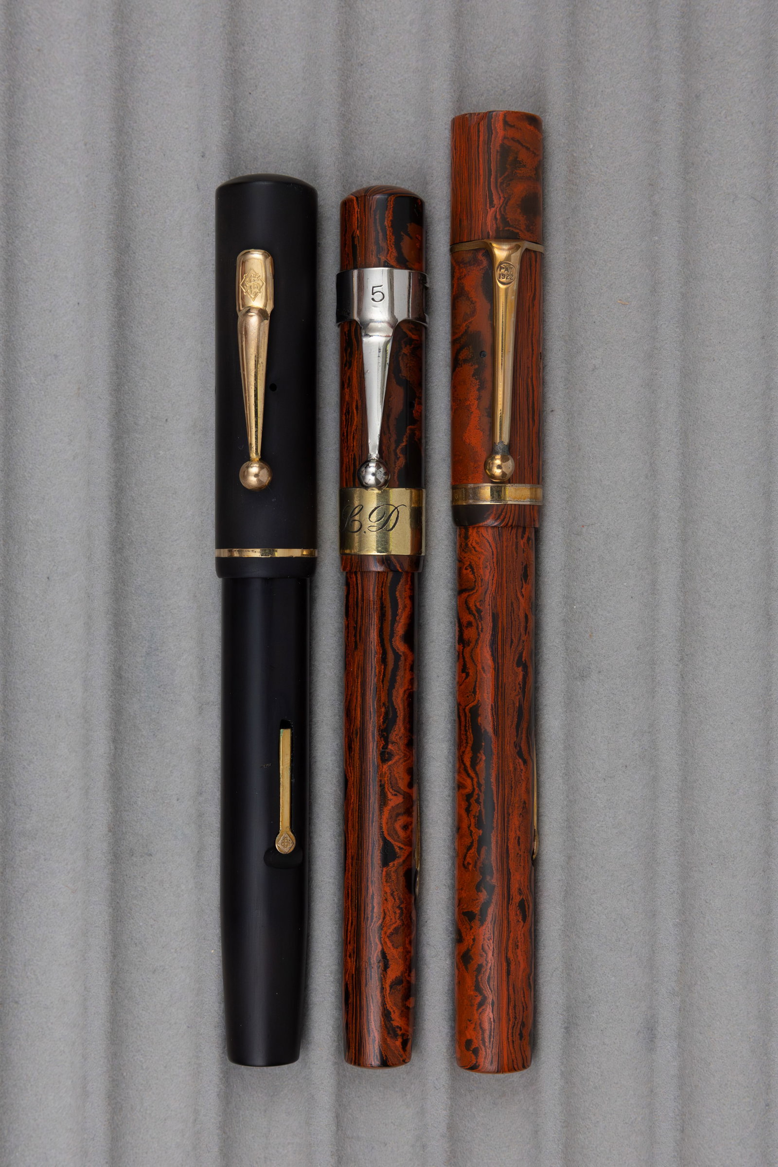 Conway Stewart and Onoto De La Rue Hard Rubber Fountain Pens: Conway Stewart and Onoto De La Rue hard rubber fountain pens (3). Conway Stewart 490M and 770 pens along with larger Onoto De La Rue red mottled pen. All fountain pens are lever fill with factory