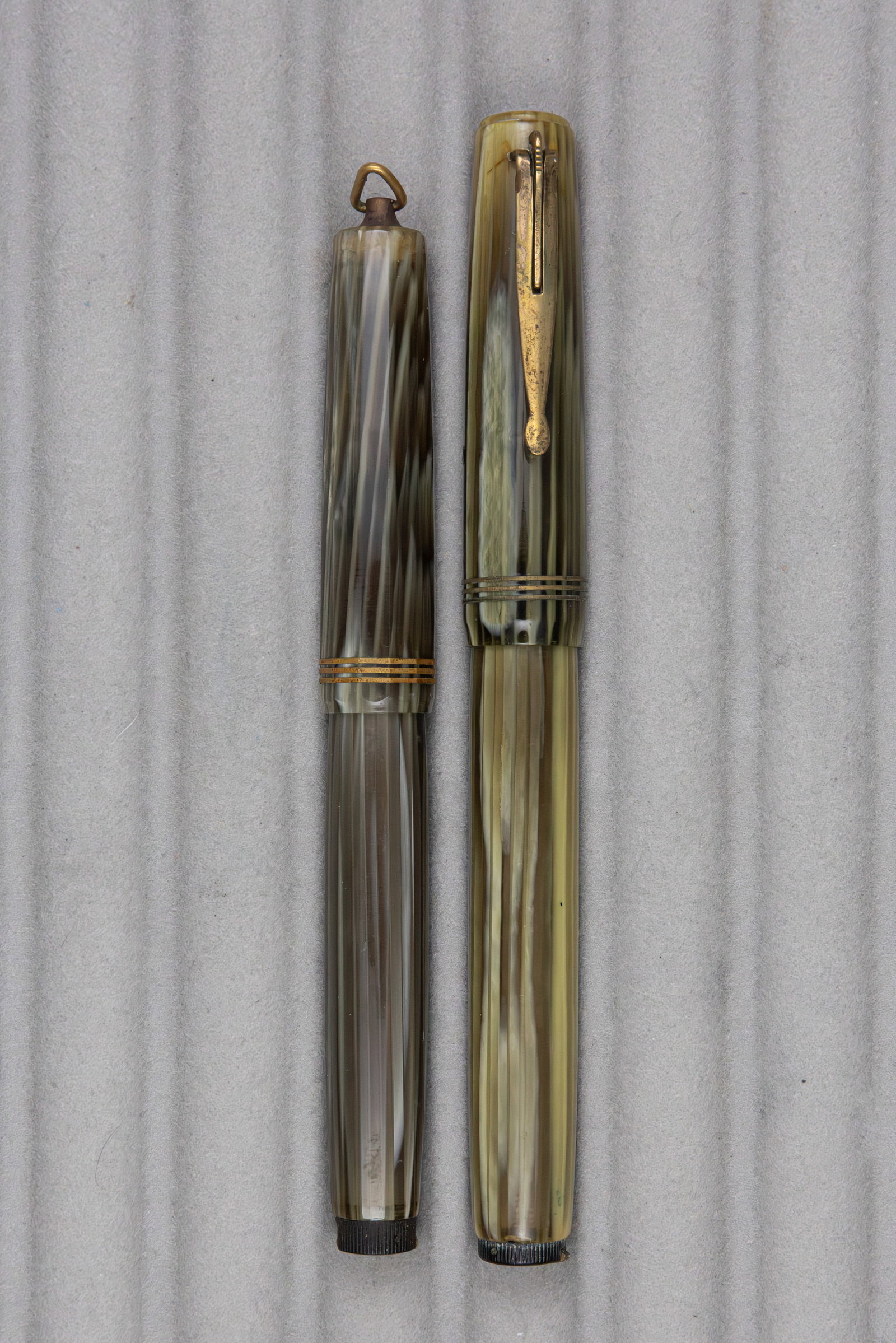 Aurora Novum Grey Pearl Marble Fountain Pens (2): Aurora Novum fountain pens in grey pearl marble (2). Larger clip version with Aurora 14K fine flexible nib along with ring top model with Aurora steel fine flexible nib. Overall fair condition, clip