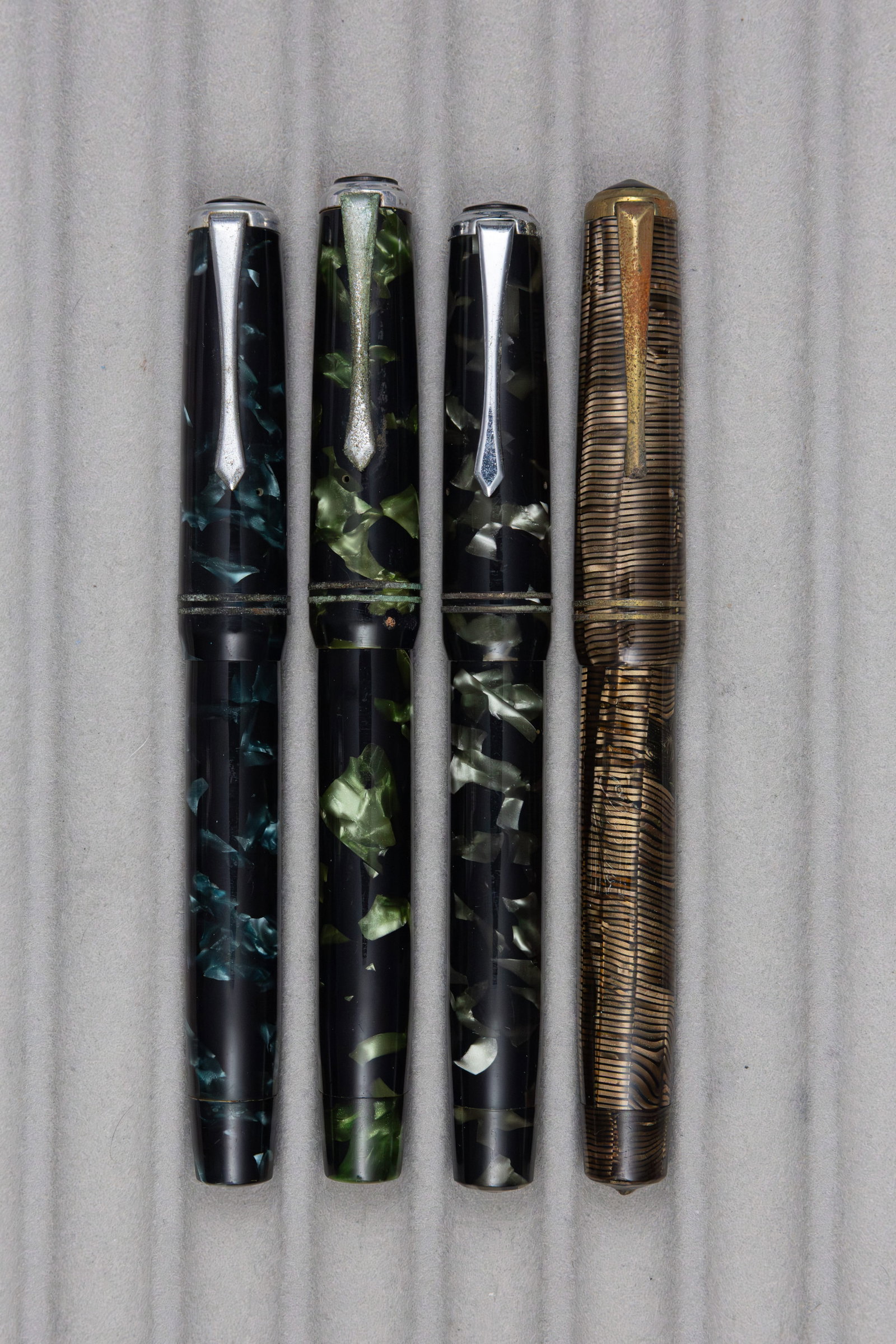 Aurora Sub-Brand Olo Fountain Pens (4): Aurora sub-brand Olo fountain pens (4). Aurora produced Olo pens, similar to that of their higher tier pens but button fill and with plain trim. These examples from the 1940s, thin metal trim shows