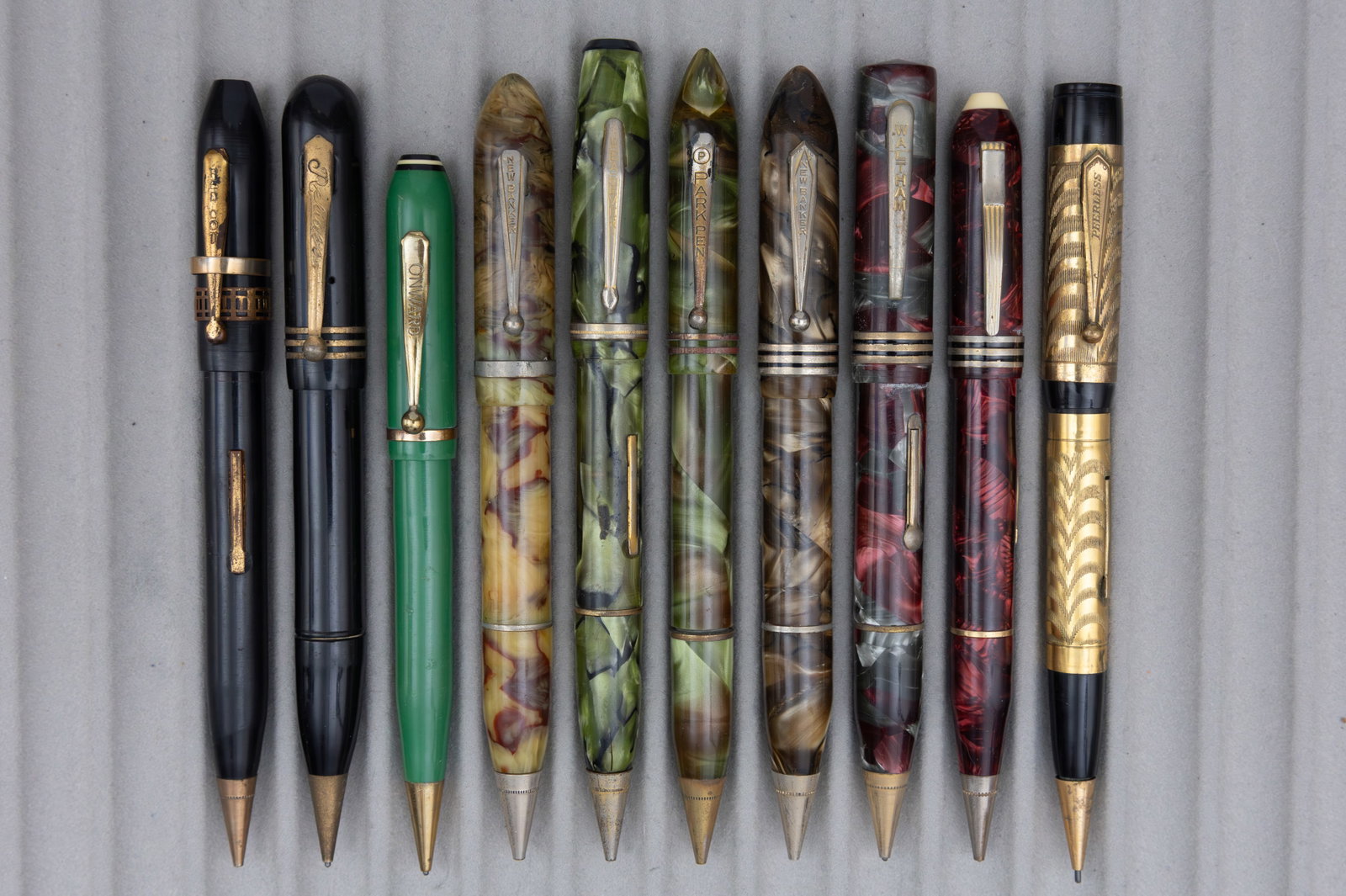 Assorted Marbleized Fountain Pen Pencil Combinations (10), Lot F: Assorted celluloid fountain pen/pencil combos (10). This lot consists of brands from M to Z alphabetically, brands such as New Banker, Remington, Waltham, Wearever and others can be found in these