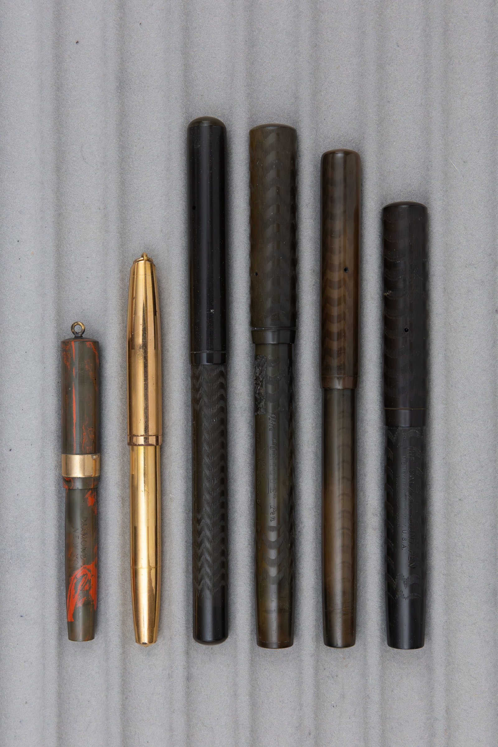 Assorted Hard Rubber Fountain Pens, Salz, Sterling, Waterman (6): Assorted hard rubber fountain pens (6). Black chased hard rubber Salz, Sterling, Unique and Waterman pens, all with correct 14K nibs. Others include red mottled hard rubber Diamond Point and gold