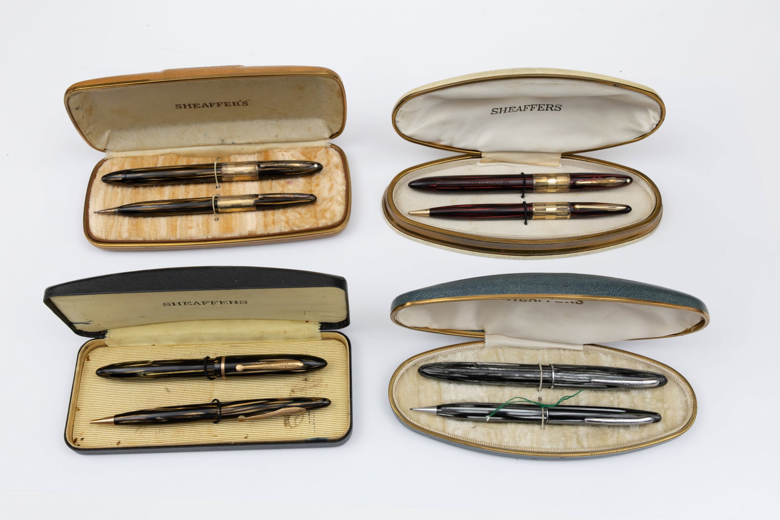 Sheaffer Striated Fountain Pen and Pencil Sets (4): Sheaffer striated fountain pen sets (4), boxed. Sheaffer striated sets from the 1930s-40s in Carmine, Gold and Grey. All fountain pens with correct Sheaffer 14K gold nibs. Overall mixed condition, fai