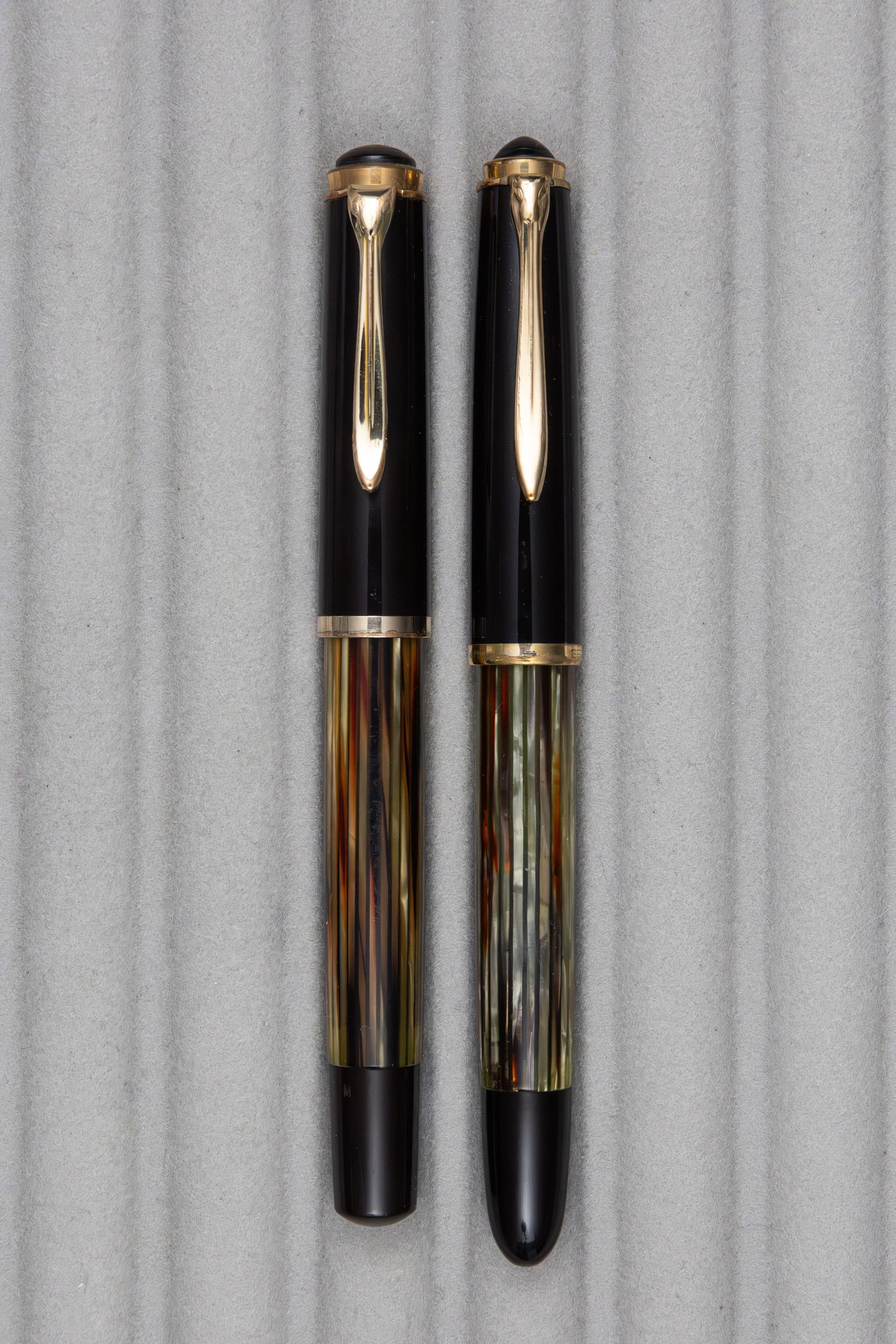 Pelikan 400 and 400NN Tortoise Striated Fountain Pens: Pelikan 400 and 400NN Tortoise striated fountain pens, circa 1950’s. Pelikan 400 with fine 14K nib and 400NN with fine flexible 14K nib. Length 5-5 1/8 inches, filling mechanisms piston fill. Ov