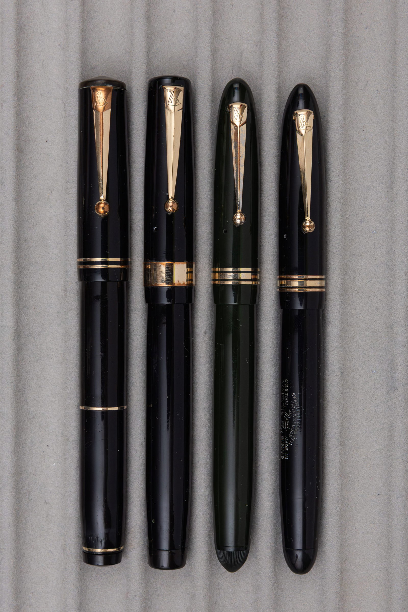 Mabie Todd Swan Leverless Fountain Pens (4): Mabie Todd Swan Leverless fountain pens (4). Three twist fill Mabie Todd Swan fountain pens in black (2) and green along with Visofil in black. All fountain pens with Swan 2 or 3 14K flexible nibs.