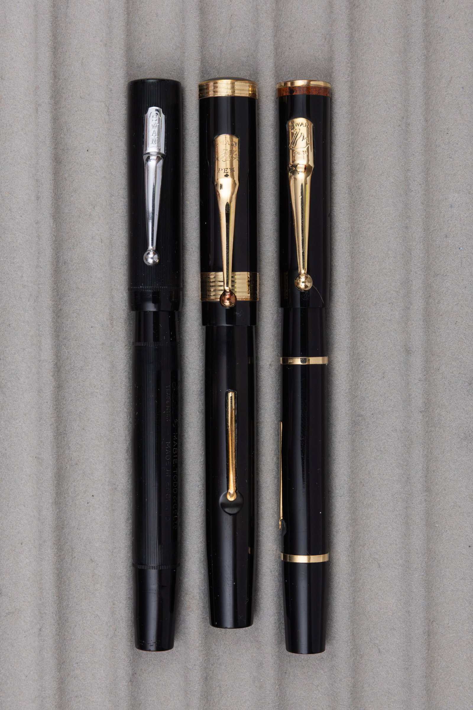 Mabie Todd Swan Black Hard Rubber Fountain Pens (3): Mabie Todd Swan black hard rubber fountain pens (3). Minor No 2 SM 2/60 pen, SF230 with mottled top and 44 external 444B/60 pen, all pieces with Swan 14K fine nibs. Overall mixed condition, most