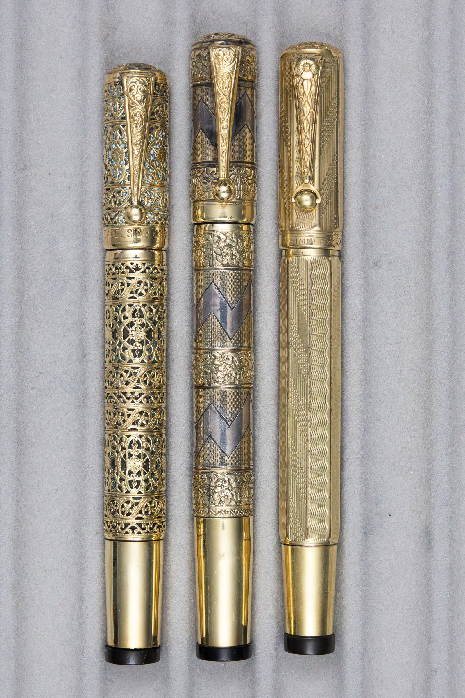 Italian Gold Filled Overlay Safety Fountain Pens (3): Italian gold filled overlay safety fountain pens (3). Caps marked Ideal, Excelsior and Simplex, all appear to be Italian 18K rolled gold overlays, Ideal pen with small split to cap, all pens with 14K 