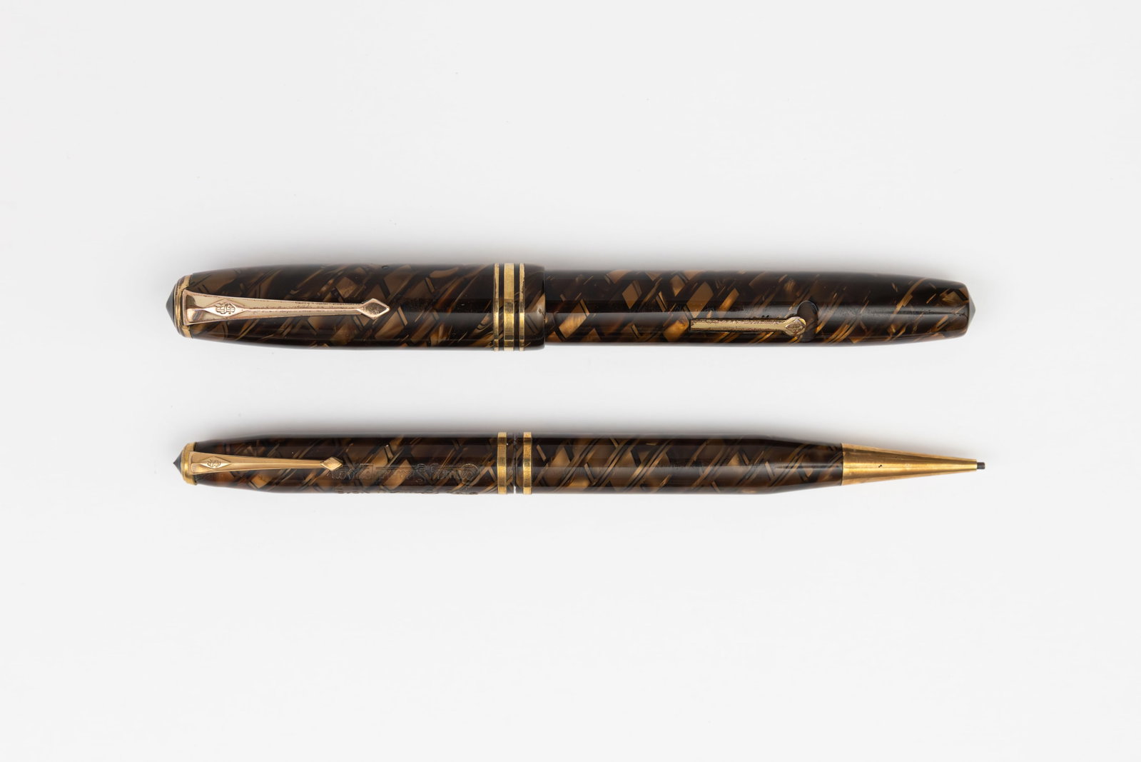 Conway Stewart 58 Tiger Eye Fountain Pen Set: Conway Stewart 58 Tiger Eye fountain pen set, circa 1950’s. Bright celluloid with gold marble with crisscross pattern, fine Conway Stewart 14K flexible nib. Length 5 inches (pencil), 5 1/8