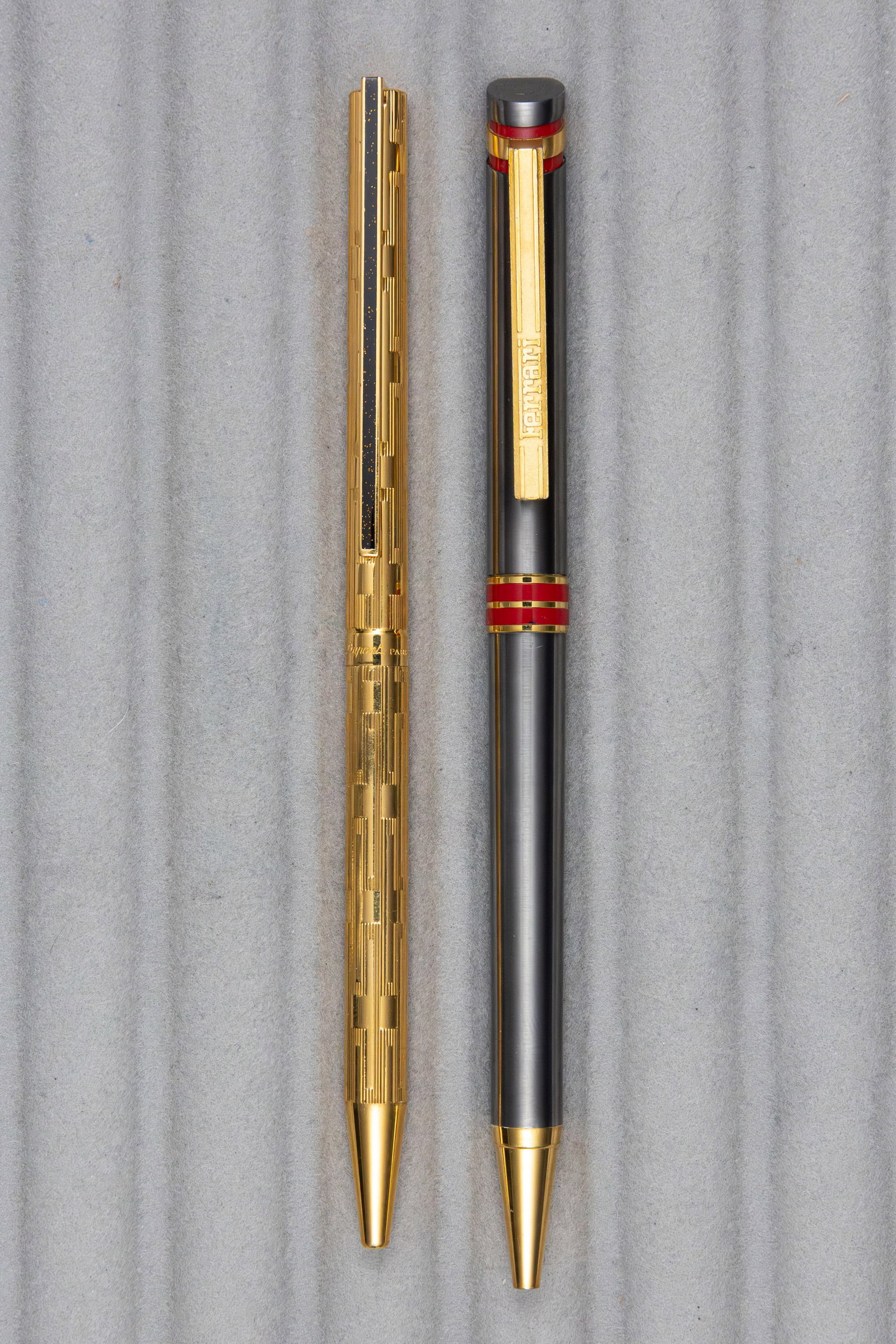 Ferrari and ST Dupont Classique Ballpoint Pens: Ferrari and S.T. Dupont ballpoint pens. Ferrari metal pen with red details and gold trim along with S.T. Dupont Classique gold plate grid pattern pen with lacquered clip. Overall excellent condition, 