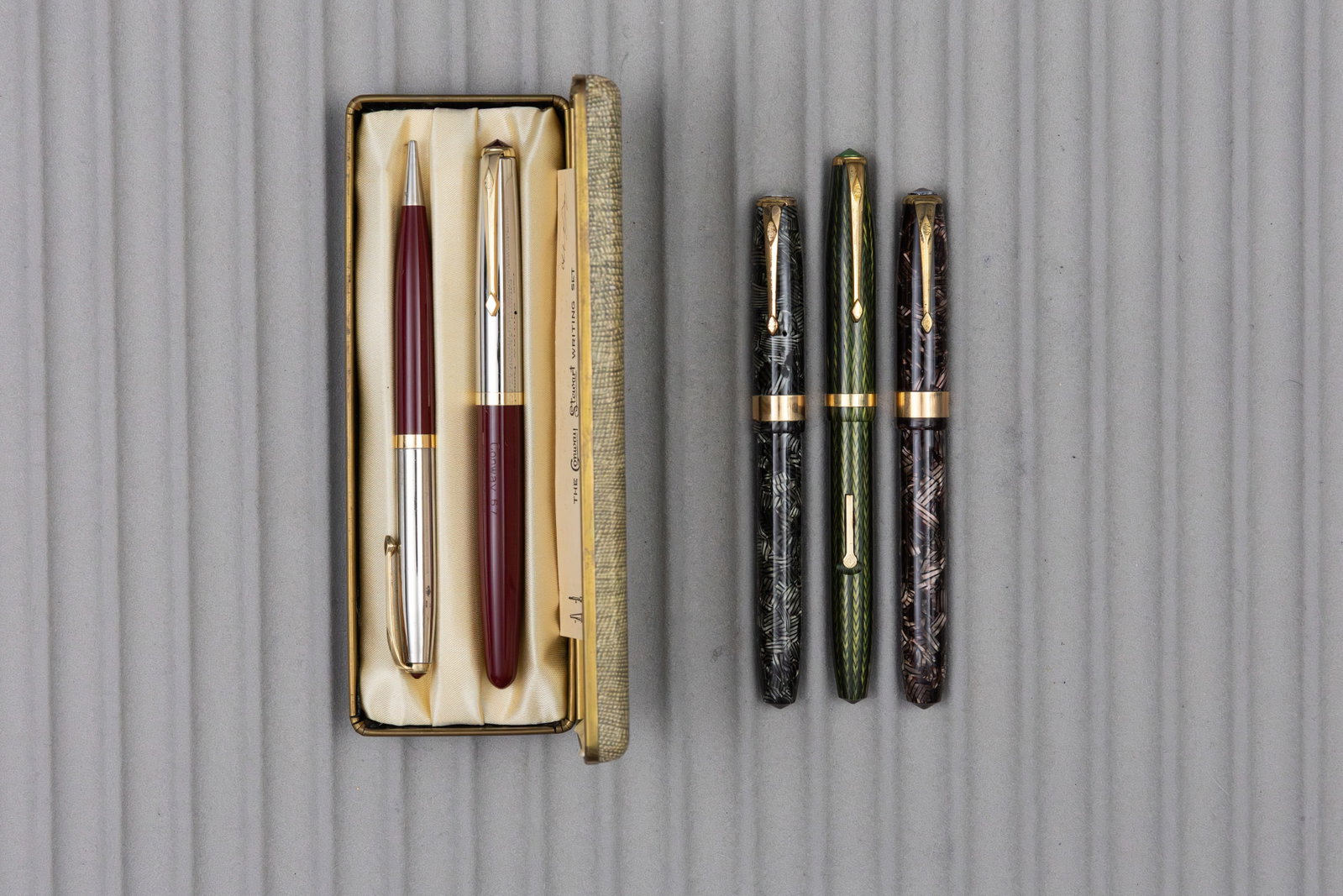 Conway Stewart Fountain Pen Lot (5): Conway Stewart fountain pens and pencil (5). Red and grey hatched 27 model pens, green herringbone Shorthand model with proper Shorthand marked nib and burgundy 67 model set. All pens with correct 14K