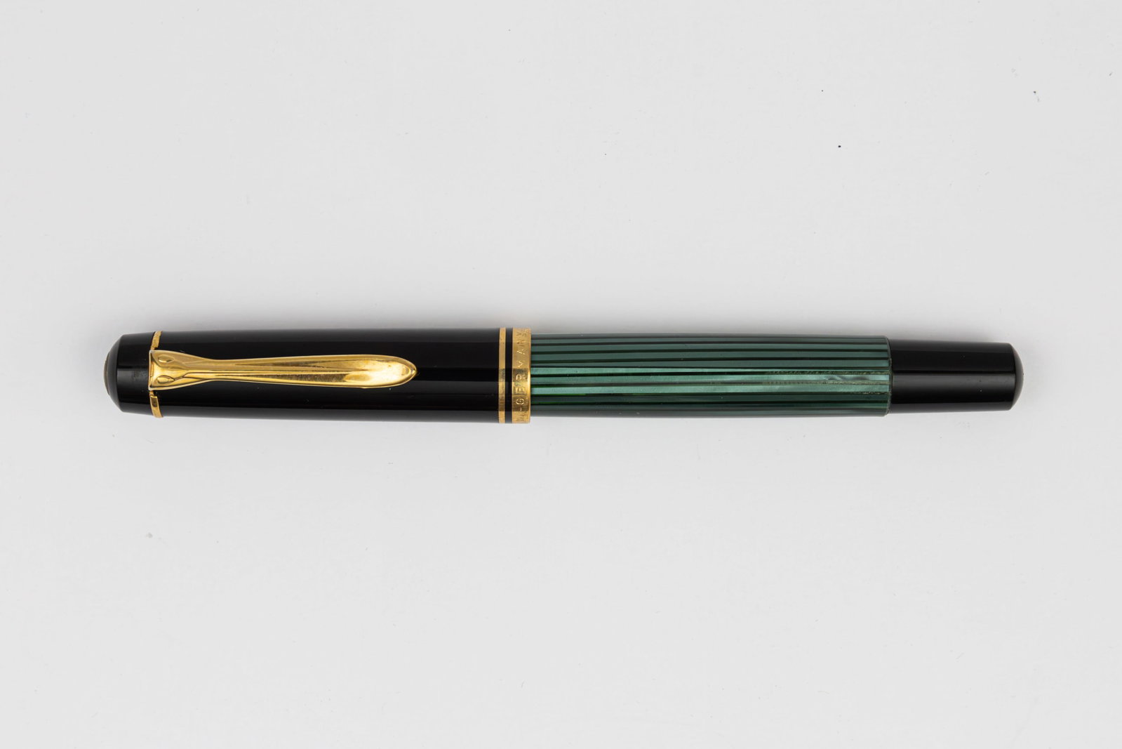 Pelikan M250 Green Striated Fountain Pen: Pelikan M250 Green Striated fountain pen, circa 1985-91. Pelikan M250 with W Germany on cap lip, black cap with green striated barrel. We cannot find an example in this colour therefore it is possible