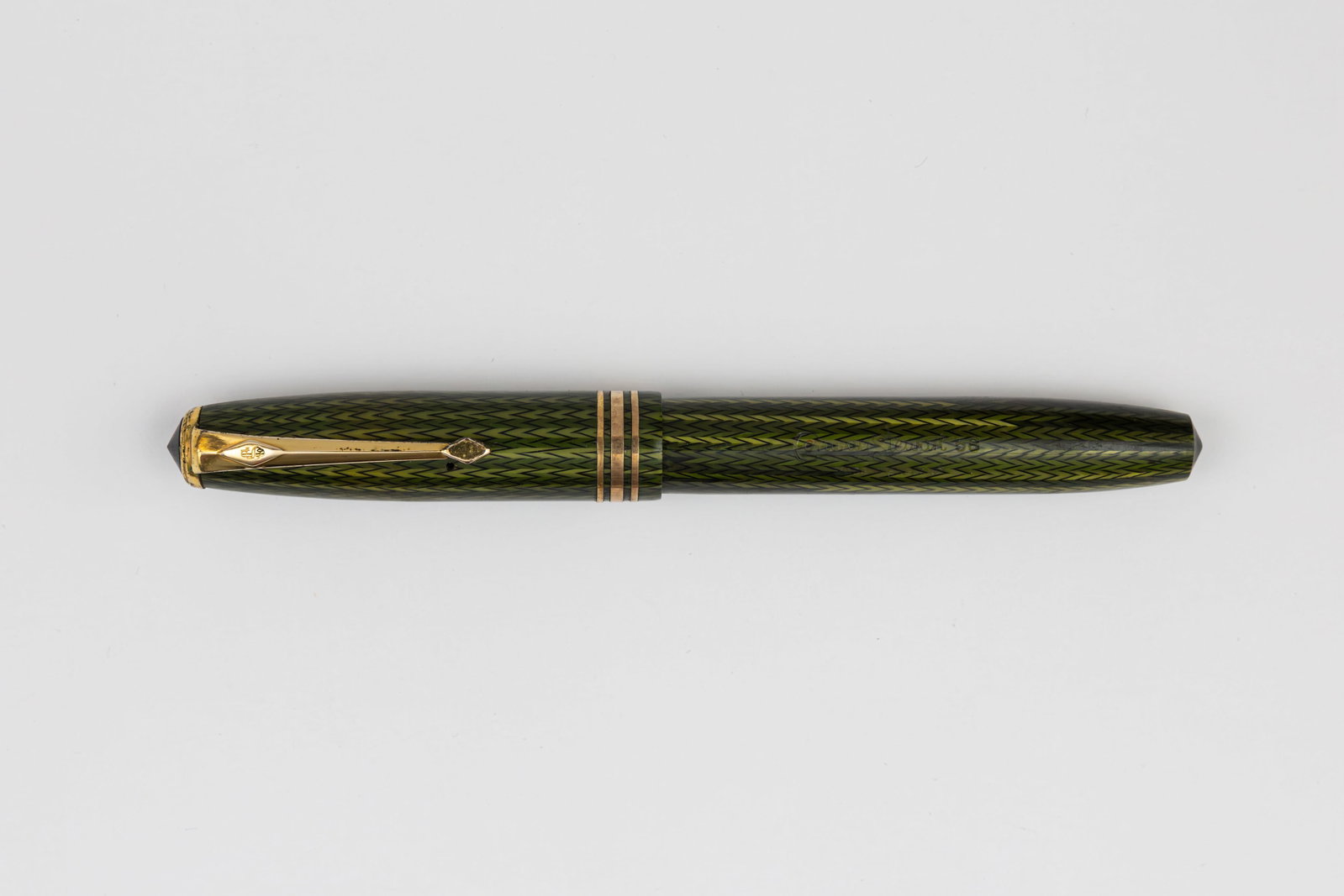Conway Stewart 58 Green Herringbone Fountain Pen: Conway Stewart 58 Green Herringbone fountain pen, circa 1950’s. Green Herringbone pattern with gold filled trim and Conway Stewart 58 14K fine nib. Length 5 1/8 inches and 6 1/4 inches posted, filli