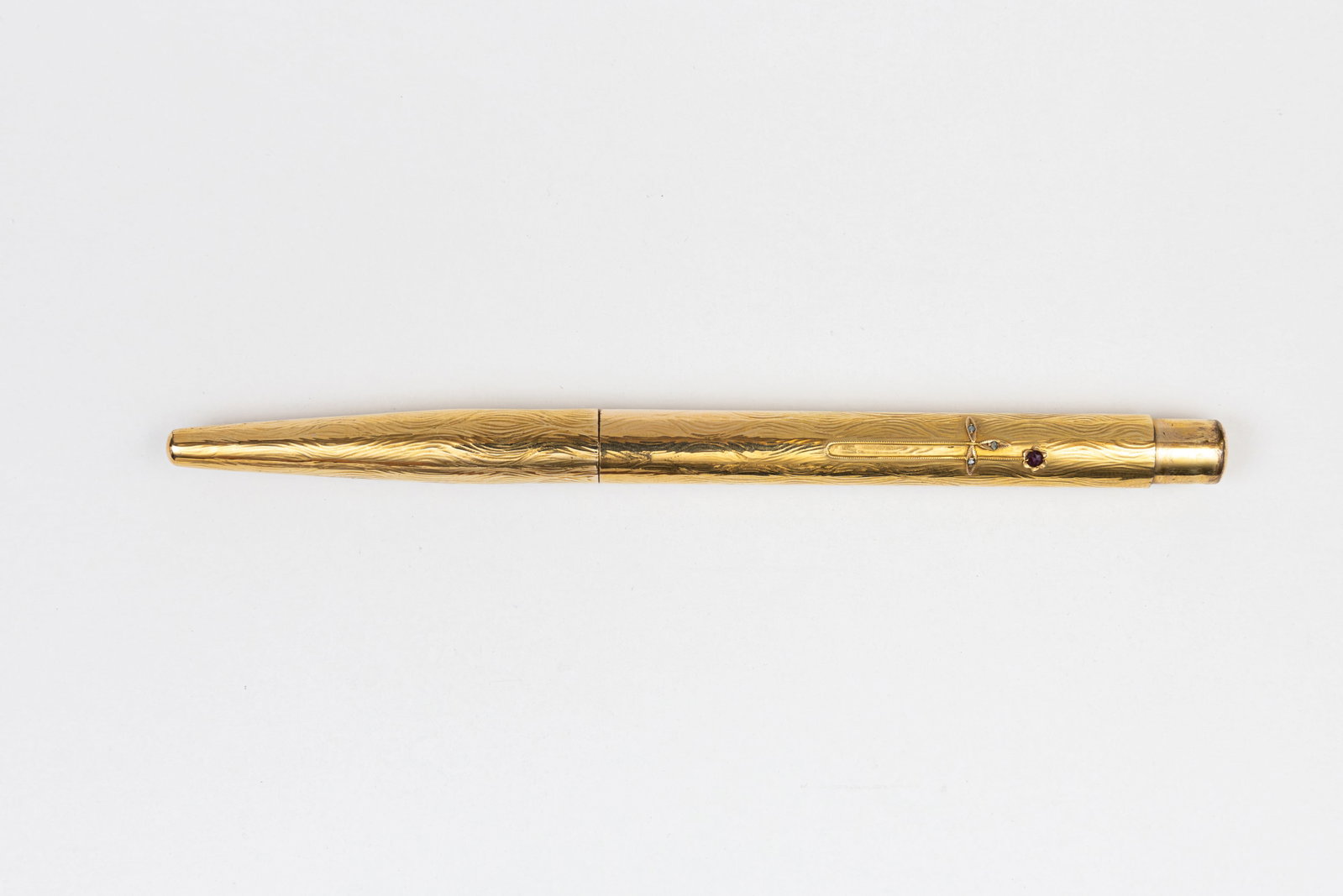 Gold Filled Overlay Taper Cap Fountain Pen, Decorative Gem Stones: Gold filled overlay taper cap fountain pen with decorative gem stones, circa 1910’s-20’s. Full overlay in wave pattern, likely gold filled as metal content is unmarked with decorative chain design