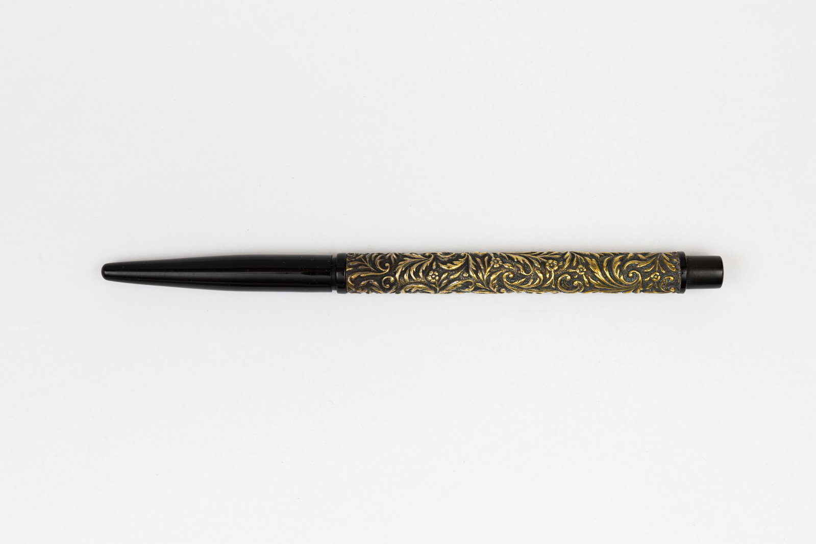 Gold Filled Overaly Taper Cap Fountain Pen, Floral Design, Flexible Nib: Taper cap gold overlay fountain pen with decorative floral pattern, circa 1910’s. Black hard rubber taper cap with gold barrel overlay, likely gold filled as metal content is unmarked with high reli