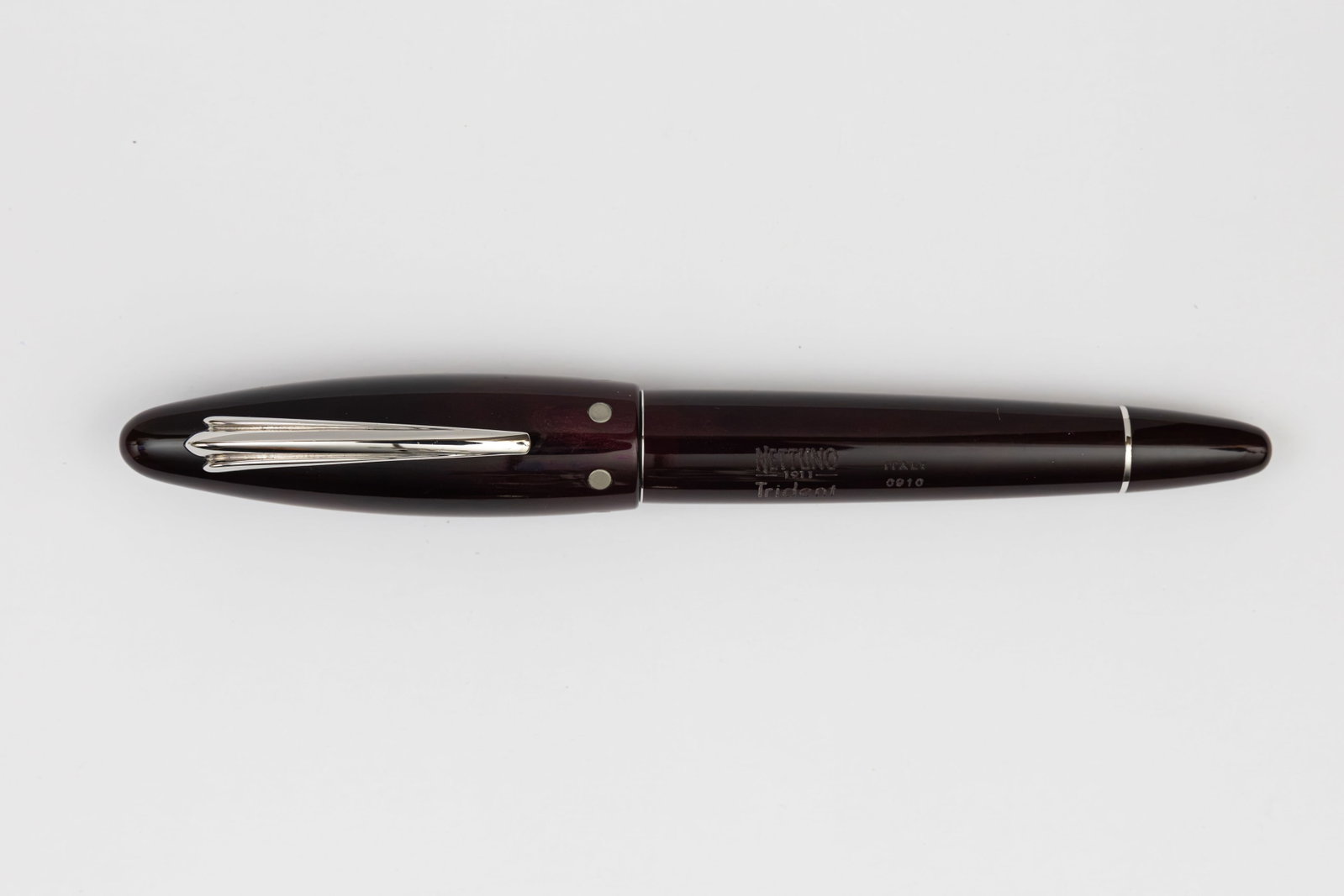 Nettuno 1911 Trident Fountain Pen, 18K Nib Boxed: Nettuno 1911 Trident fountain pen with box, outer box and papers. Burgundy marble and silver trim with magnetic cap closure, marked 0911 on barrel with 18K medium nib. Length 5 3/4” and 6”