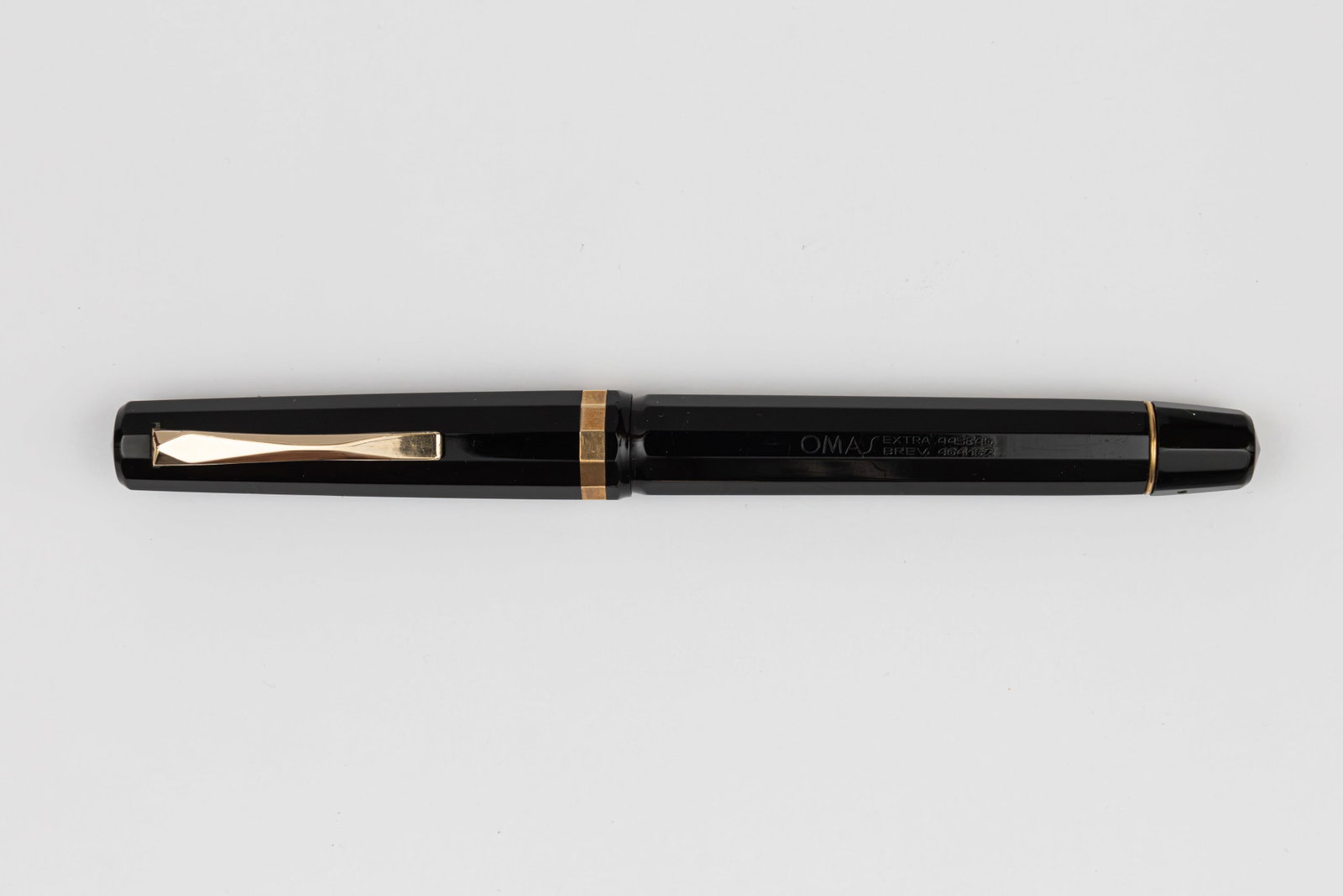 Omas 556 Faceted Black Fountain Pen: Omas 556F black fountain pen, circa 1950. Omas 556 faceted fountain pen in black with Omas 14K fine flexible nib. Length 5 3/8” and 6 1/2” posted, filling mechanism piston fill. Overall ex