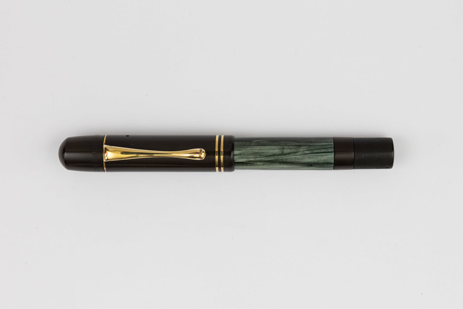 Pelikan 100 Green Marble Fountain Pen: Pelikan 100 green marble fountain pen, circa 1933-37. Pelikan 100 in green marble with hard rubber cap and fluted piston knob and Pelikan 14K fine flexible nib. Length 4 5/8” and 6 1/4” po