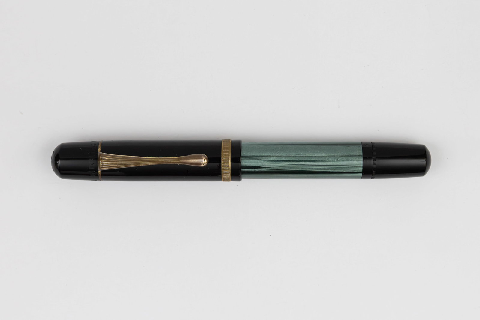 Pelikan 100N Green Marble Fluted Cap Band Fountain Pen: Pelikan 100N green marble fluted cap band fountain pen, circa 1937-54. Even colour with clean window, marked M on piston knob with Pelikan CN (chromium nickel steel) medium nib. Length 4 3/4” an