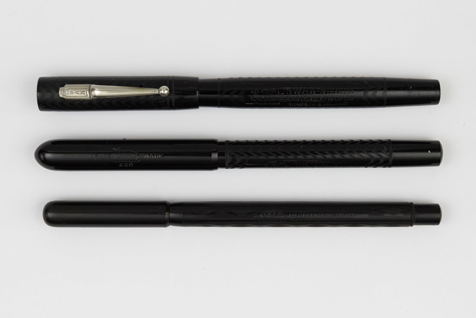 Mabie Todd Swan Black Chased Hard Rubber Fountain Pens, Boxed (3): Mabie Todd Swan black chased hard rubber fountain pens, boxed (3). SM1/60 with nickel clip, black lever and Swan 1 14K fine flexible nib. 3013 black chased dropper fill fountain pen with fine 14K nib 