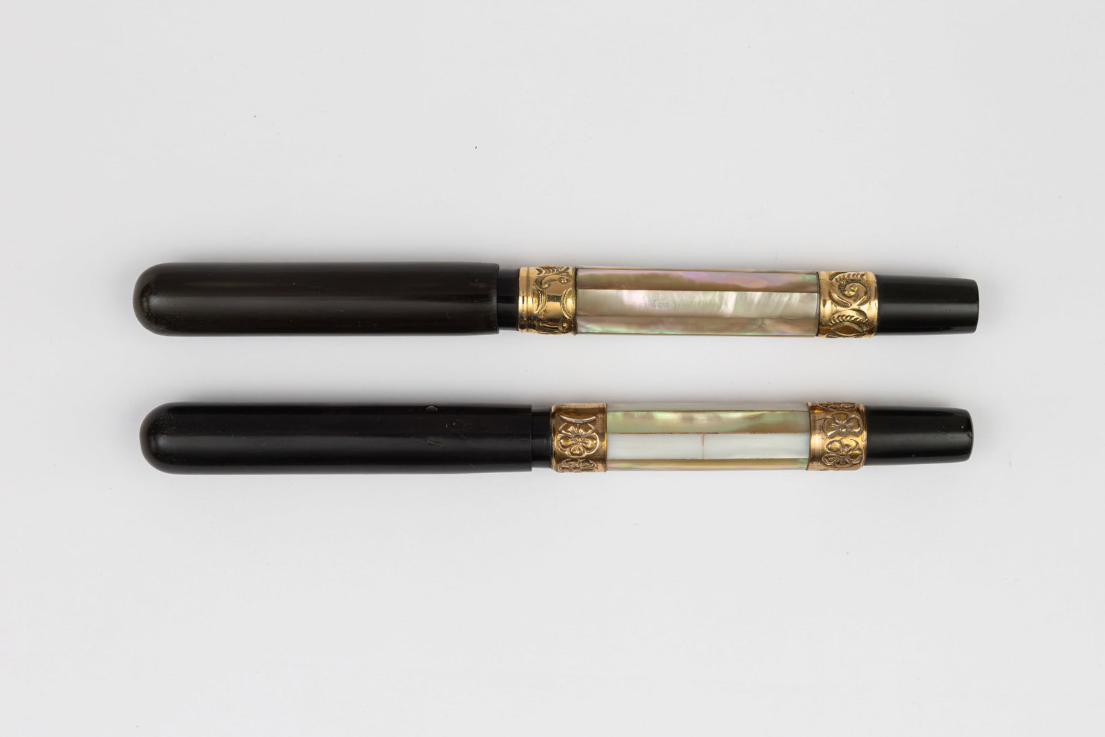 Mother of Pearl, Abalone Faceted Gold Banded Fountain Pens (2): Mother of pearl and abalone faceted overlay fountain pens. Black hard rubber fountain pens with faceted barrels in abalone and alternating abalone and pearl panels with gold filled upper and lower ban