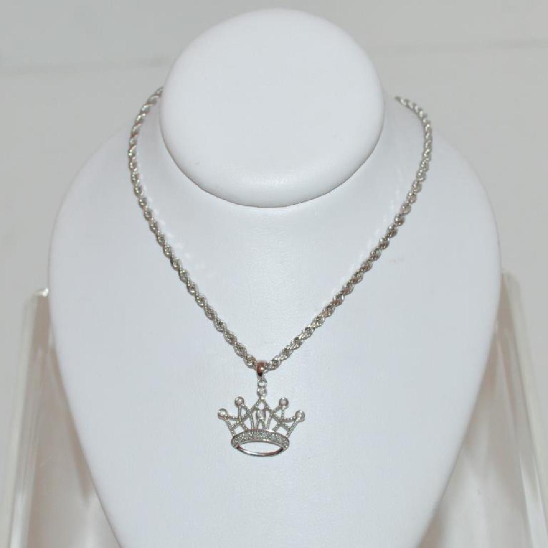 14kt white gold diamond crown pendant: Ladies 14kt white gold diamond crown pendant featuring round brilliant cut diamonds weighing approx. 0.12ct. handing from a 20" rope chain. Weight 5.8 grams