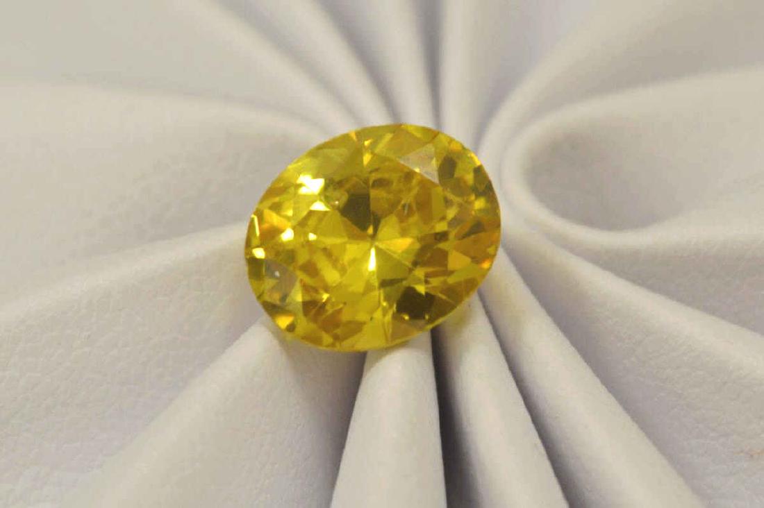 Loose 6.50ct yellow zircon: Loose 6.50ct oval cut yellow zircon. Measures approx. 10 x 9 x 5mm. Comes with a GTLI certificate.