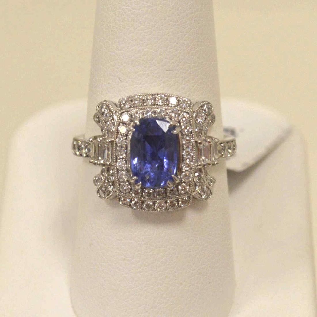 Platinum sapphire and diamond ring: Ladies platinum sapphire and diamond ring featuring a prong set oval cut very slightly grayish violetish blue sapphire weighing approx. 2.31ct.. accented with a stylized double halo of prong set bague