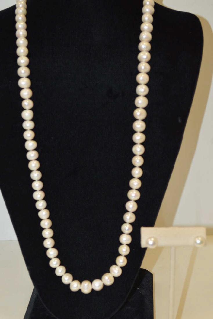 32" Freshwater Pearl Necklace and Earrings: Ladies 32" fresh water pearl necklace featuring single knotted 10-11 mm baroque creamy white color pearls and finished with a gold toned pearl clasp. Also includes 6.5mm matching pearl stud earrings.