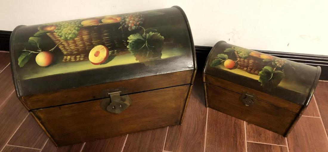 Pair of Matching Wooden Arch Top Trunks: Pair of Matching Wooden Arch Top Trunks. Both are painted with a fruit basket still life on the outside top. They have brass tone hinges, clasps, handles and feet. The larger one is 19" wide, 13" deep