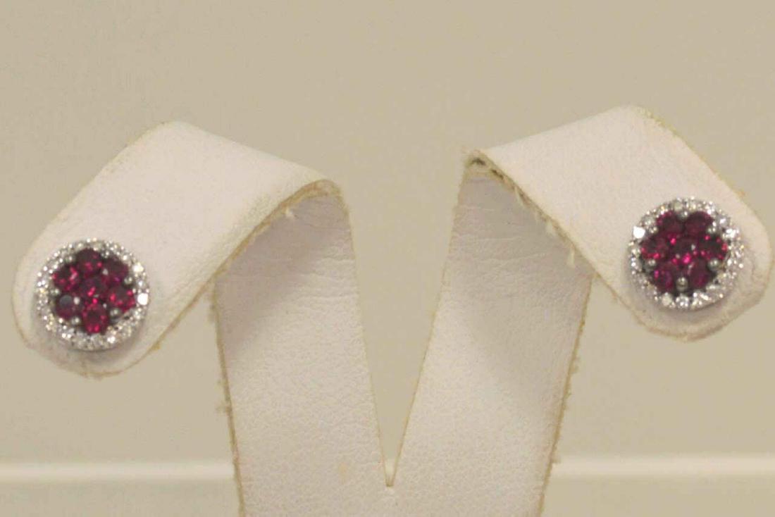 14kt white gold ruby and diamond cluster earrings: Ladies 14kt white gold ruby and diamond cluster earrings featuring a cluster of round cut rubies weighing .75ct, surrounded by a halo of round brilliant cut diamonds weighing .33ct.. Weight 2.7 grams