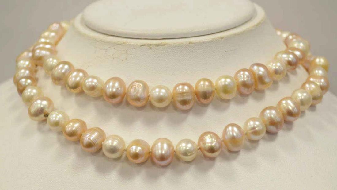 32" Freshwater Pearl Necklace and Earrings: Ladies 32" fresh water pearl necklace featuring single knotted 9-10 mm baroque creamy white and pink color pearls. Finished with a gold toned lobster clasp. Also includes matching stud earrings.