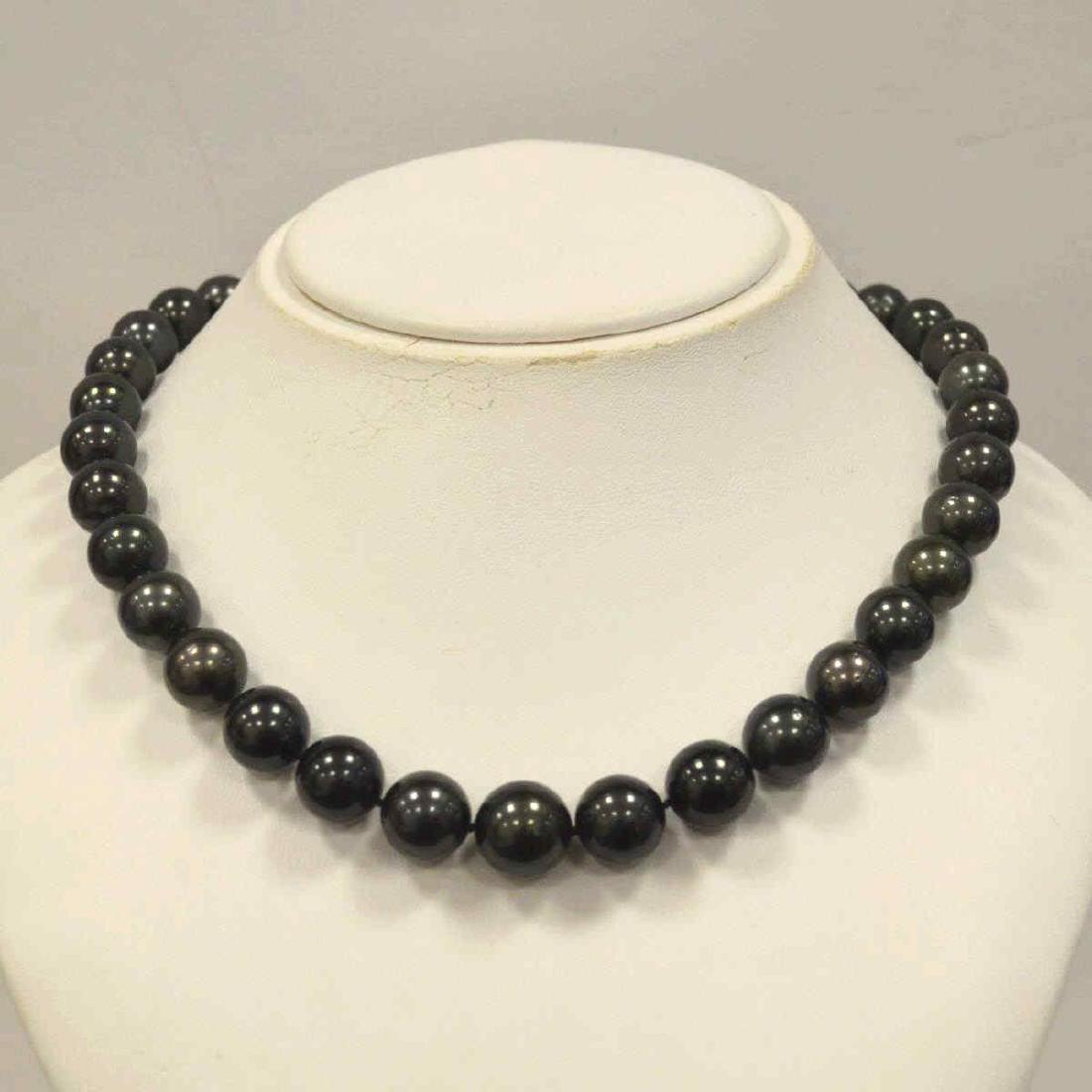 18" Tahitian Pearl Necklace: Ladies 18" Tahitian pearl necklace featuring single knotted graduated 11-14mm very dark gray Tahitian pearls with purple overtone. Finished with 14kt plunger clasp. Comes with an AIGL appraisal. NK011