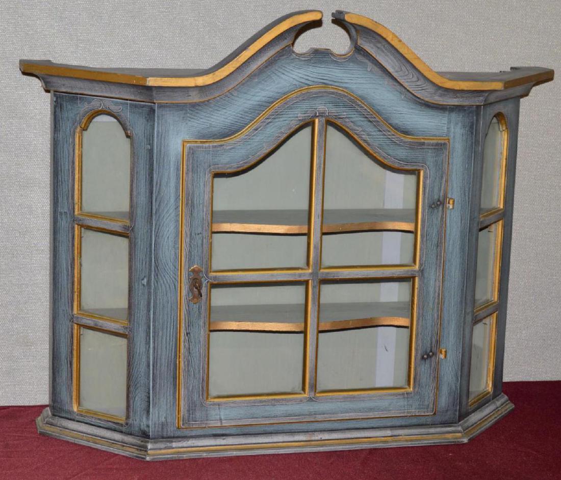 Wall Hanging Arch Top Curio Cabinet Glass with Key: Wall Hanging Arch Topped Curio Cabinet with Glass Arched Door & Windows Gold Gilt Edges, with Key. Blue\Grey painted finish with gold trim. Angular or bay type front with two gold trimmed stationary s