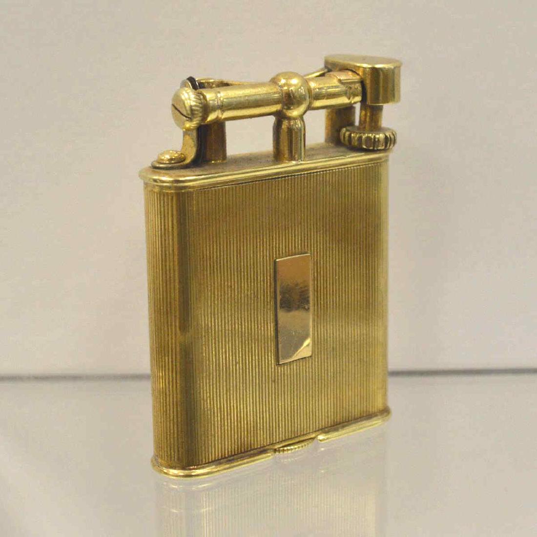 14kt yellow gold Dunhill Lighter: 14kt yellow gold Dunhill lighter featuring a 14kt yellow gold outer jacket with a ridged texture and space for monogram. Not currently working. Measures 52. x 37.5mm. Gross weight 44.8 grams. Dent on