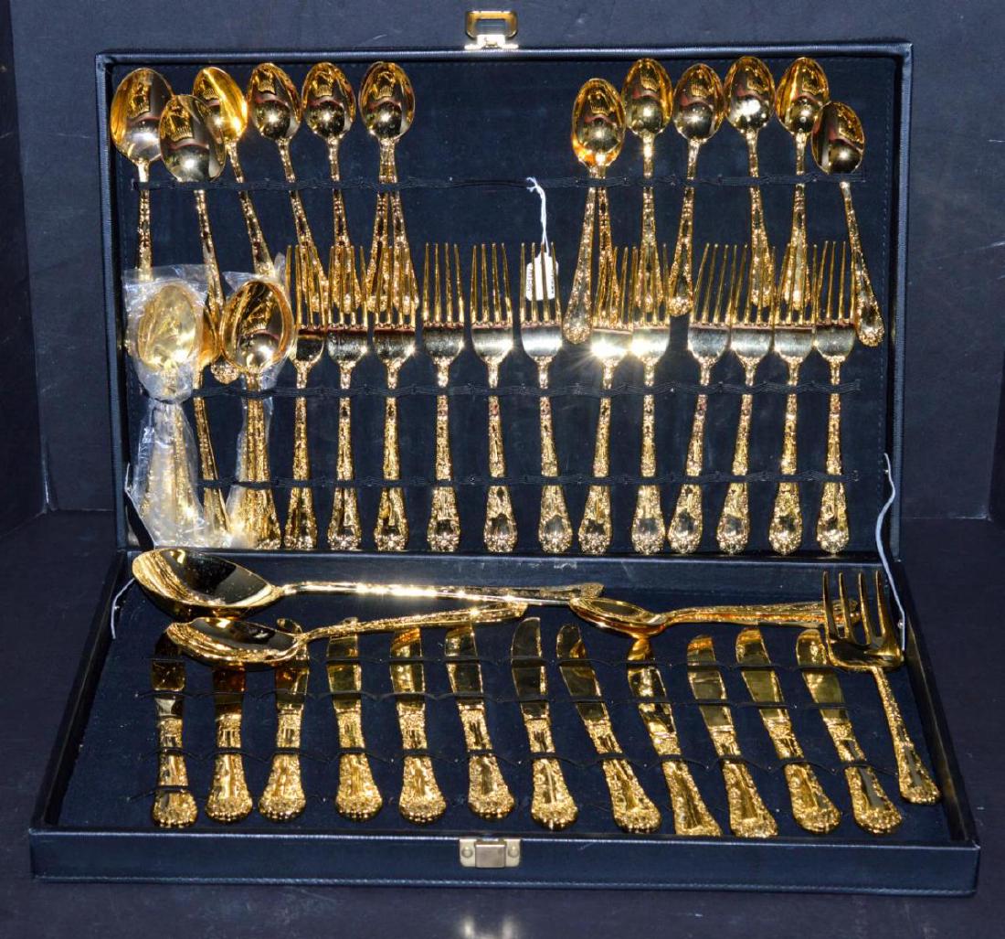 Gold Plated 12 Place Setting of Flatware in Case: Fancy Gold Plated 12 Place Setting of Flatware in Black Case. The set includes: 12-Place Knives, 12-Place Spoons, 12-Soup Spoons, 12-Dinner Forks, 2-Medium Service Spoons, 1-Large Service Fork, 1-Larg