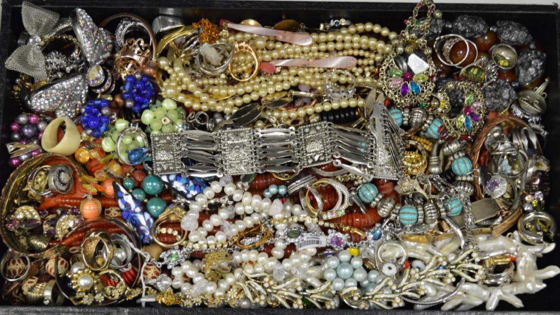 Large lot of costume jewelry: Large lot of costume jewelry including large dangle earrings, fancy link bracelets, large bee cuff bracelet, beaded necklaces, cocktail rings, and many pairs of earrings.