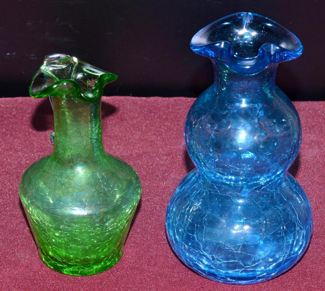 Pair of Hand Blown Crackle Glass Bud Vases: Pair of Hand Blown Crackle Glass Bud Vases. Green tapered side crackle glass miniature vase or pitcher with formed lip. It is 5" tall with a clear handle. Blue bulbous crackle glass handled vase or pi