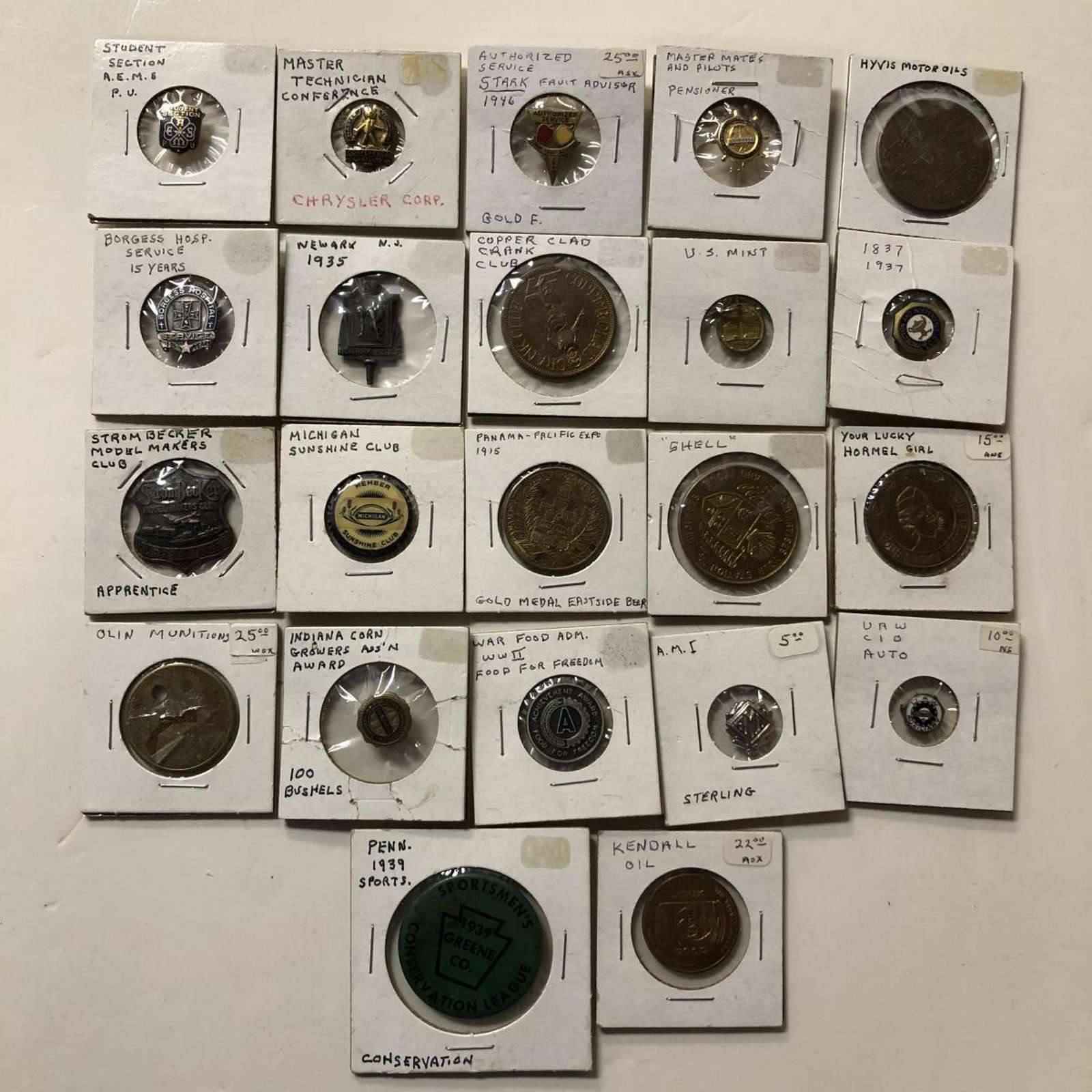 22 Pins Tokens Medals Neat Exonumia Lot: This grouping of exonumia contains 22 items. We spot a Lucky Hormel Girl, Crank Club token, Hyvis Motor Oils token, a 1915 Panama-Pacific Expo small medallion, Strom Becker Apprentice Badge, and a lot