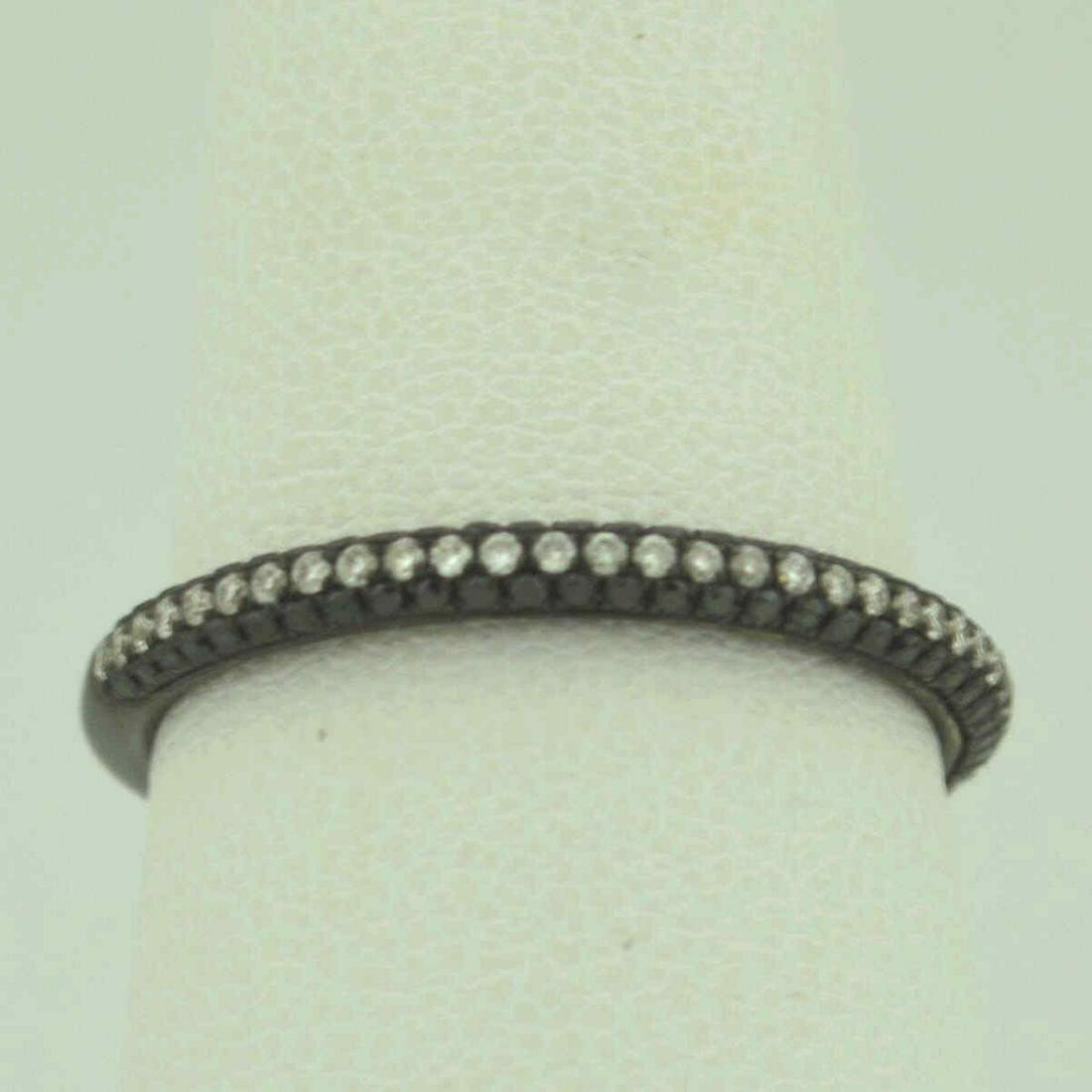 18kt white and black diamond fashion band: Ladies 18kt gold diamond wedding band by Cheri Dori featuring round brilliant cut black diamonds weighing .11ct and black round brilliant cut diamonds weighing .22ct. High polish black rhodium finish.