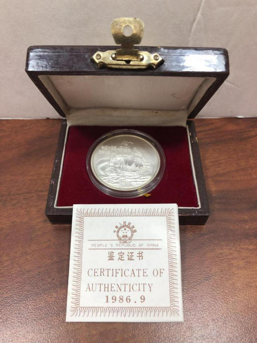 1986 Silver 5 Yuan China Clipper Ship w/Box & COA: 1986 Silver 5 Yuan China Clipper Ship w/Box & COA. Housed in its original wood box with COA and slipcover, is this silver 5 Yuan coin from China. Featuring featuring the Great Wall on one side and the