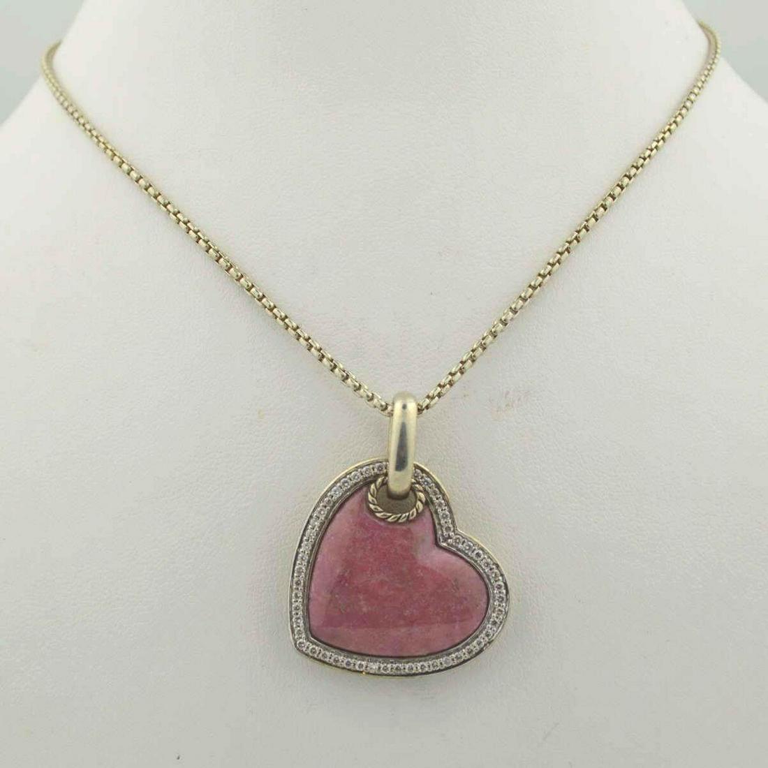 Sterling David Yurman Heart Necklace: Ladies sterling silver cable heart pendant featuring a heart shaped cabochon cut rhodonite center stone. Accented with a frame of prong set round diamonds weighing approx. 0.34ct.. Haning form a 18" b